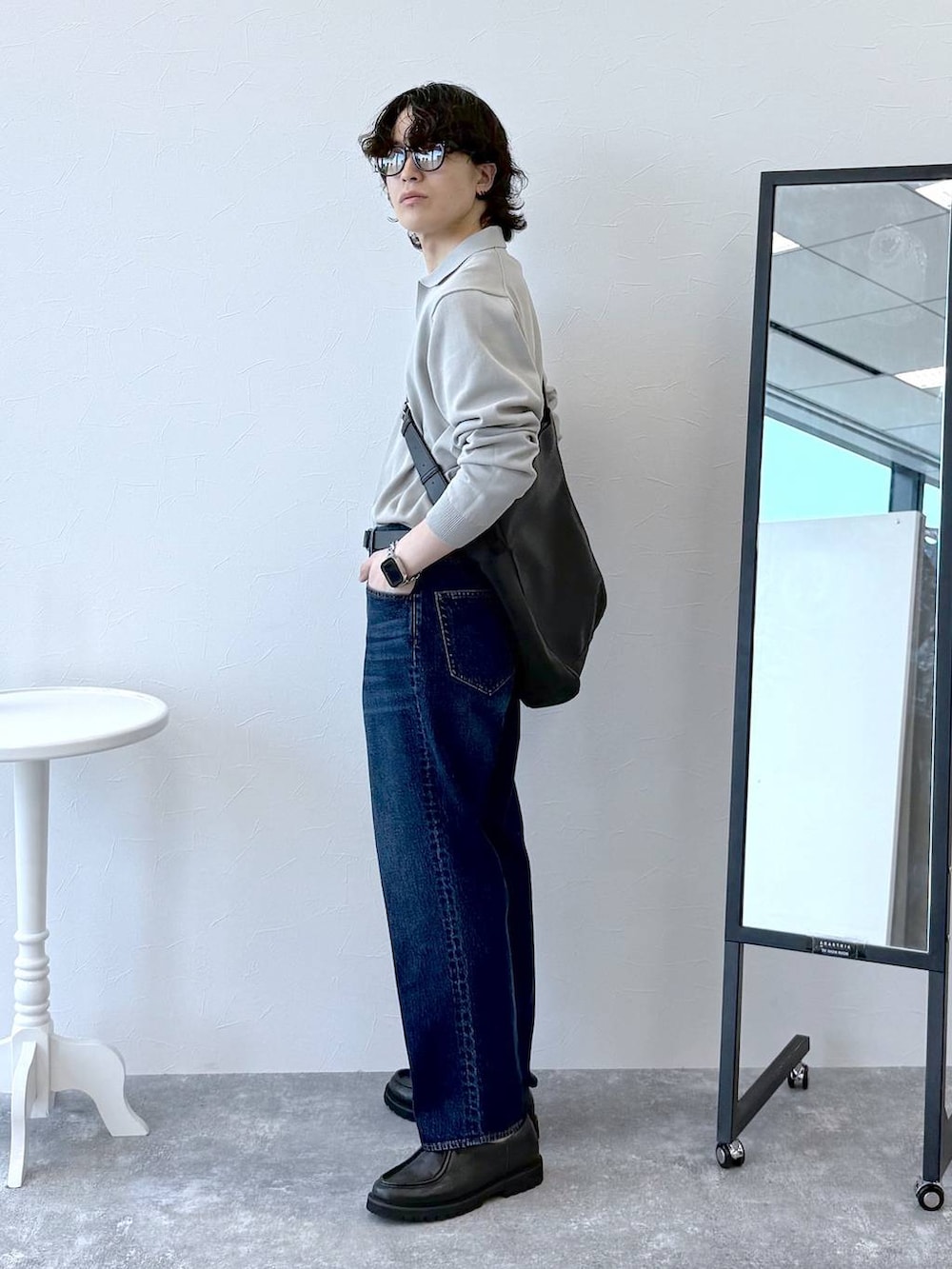 ブルー系のデニムパンツ、ベージュ系のニット/セーター、ブラック系のその他シューズを着用したメンズの秋コーディネートの3枚目の写真