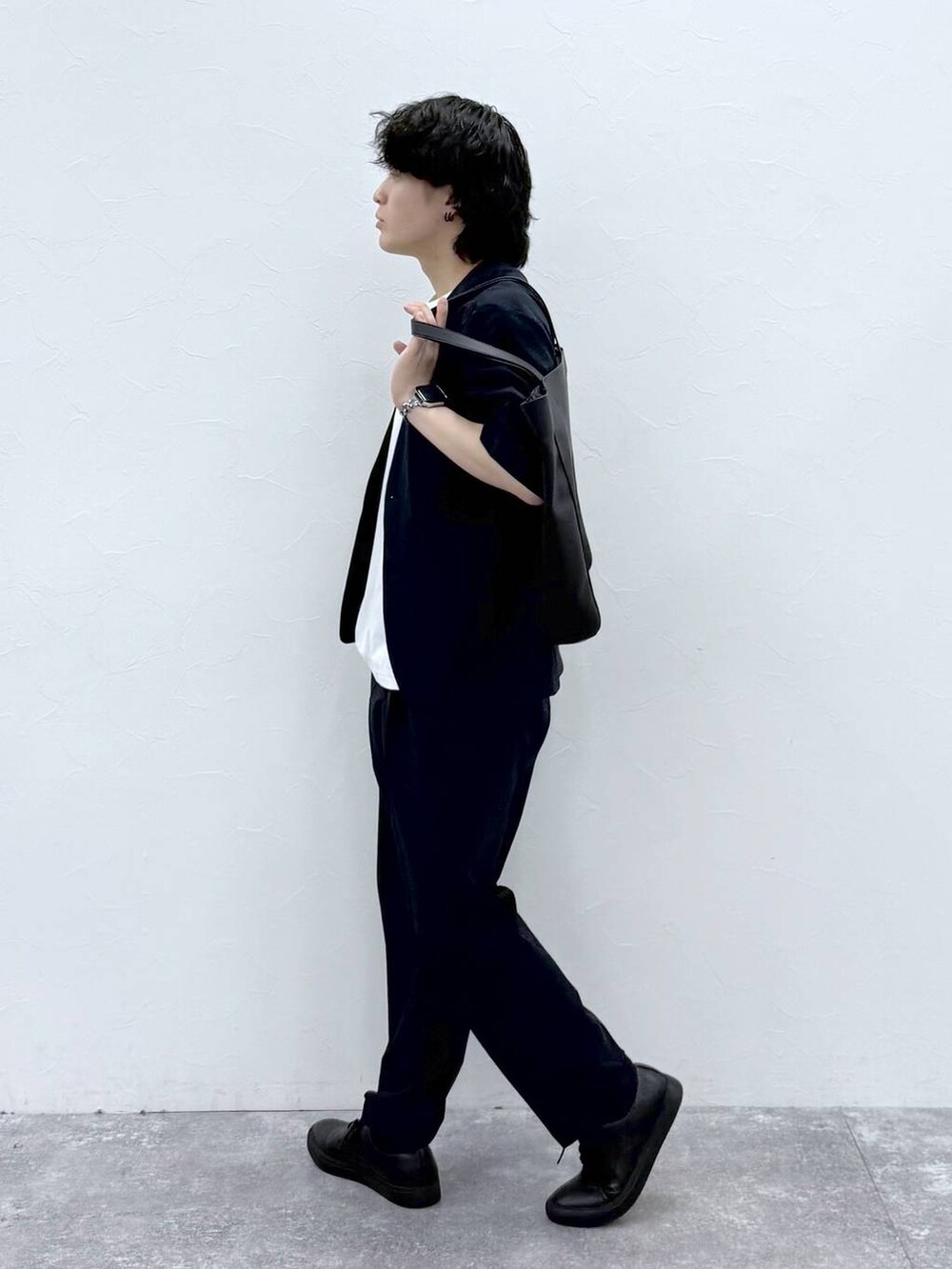 ブラック系のトートバッグ、ホワイト系のTシャツ/カットソー、ブルー系のノーカラージャケットを着用したメンズの春コーディネートの3枚目の写真