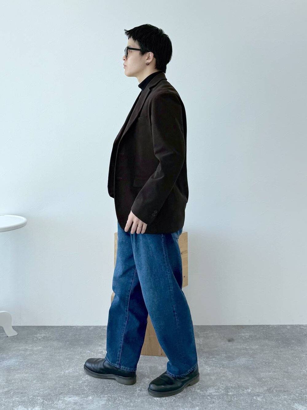 ブラック系のニット/セーター、ブラウン系のテーラードジャケット、ブルー系のデニムパンツを着用したメンズの秋コーディネートの4枚目の写真