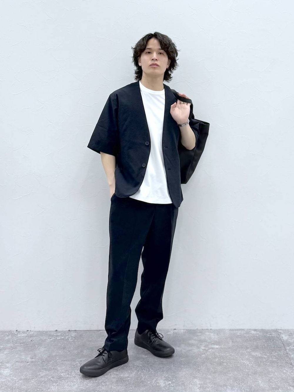 ブラック系のトートバッグ、ホワイト系のTシャツ/カットソー、ブルー系のノーカラージャケットを着用したメンズの春コーディネートの2枚目の写真