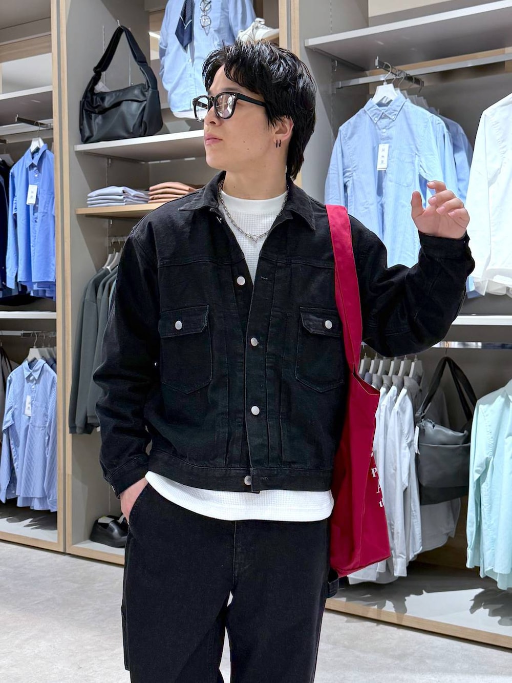 ホワイト系のスウェット、レッド系のトートバッグ、ブラック系のデニムジャケットを着用したメンズの春コーディネートの6枚目の写真