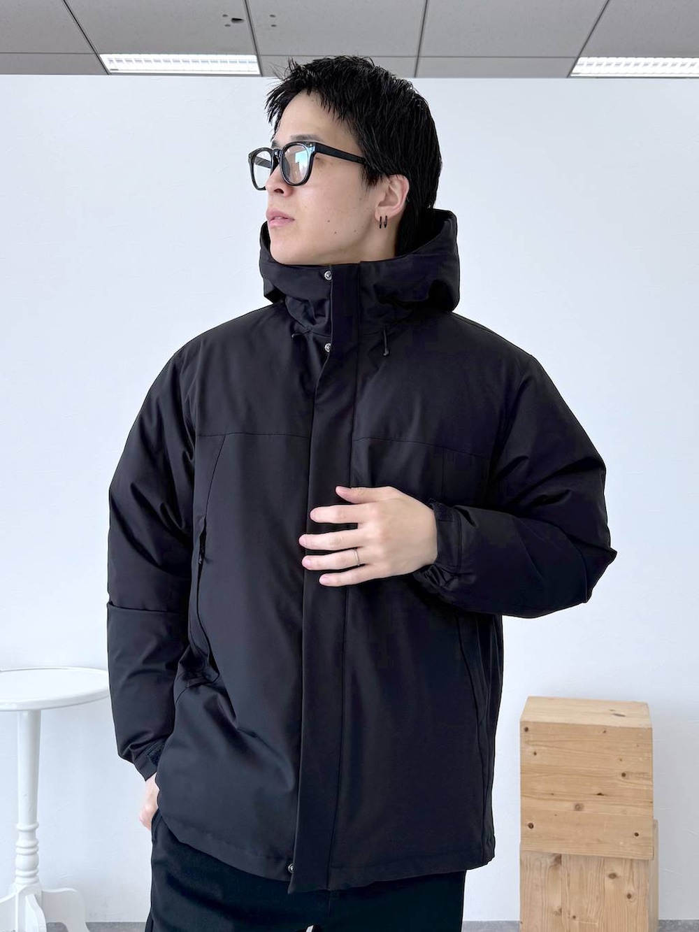 ブラック系のダウンジャケット/コート、ブラック系のその他パンツ、ホワイト系のTシャツ/カットソーを着用したメンズの冬コーディネートの6枚目の写真