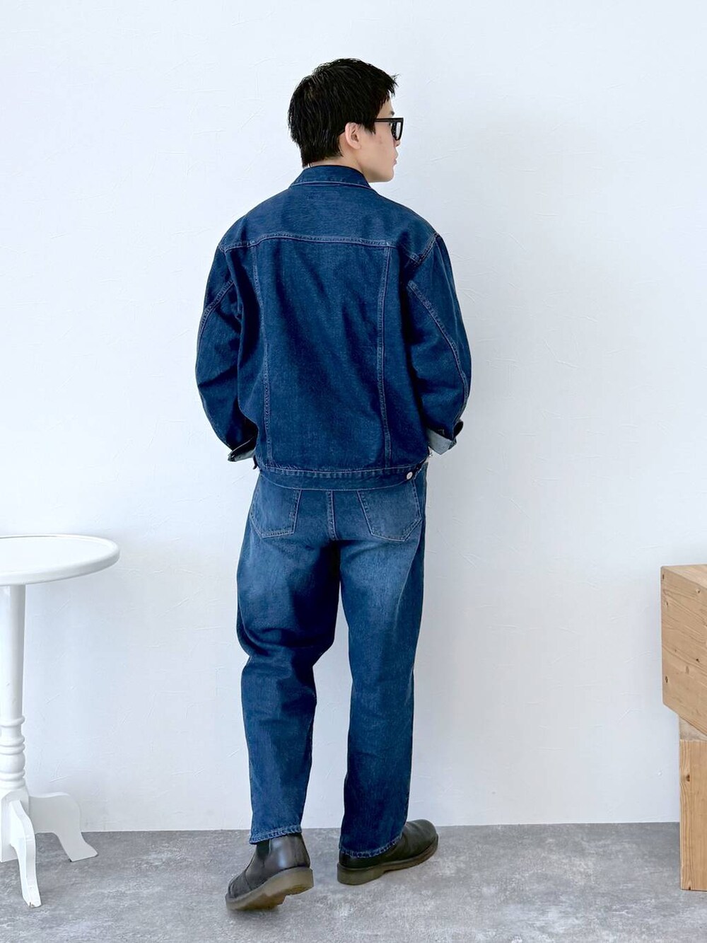 ブラック系のニット/セーター、ブルー系のデニムジャケット、ブルー系のデニムパンツを着用したメンズの秋コーディネートの5枚目の写真