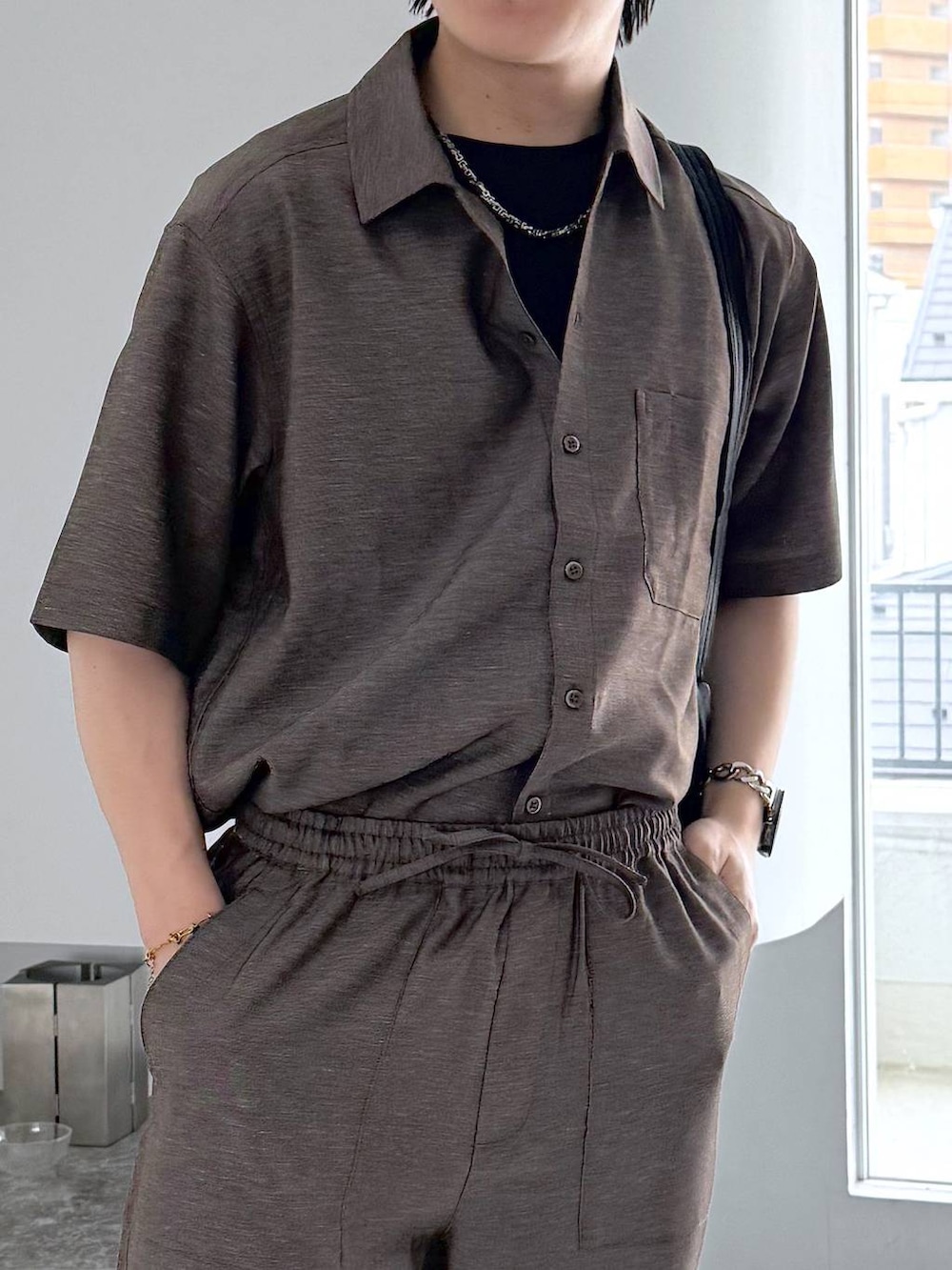 ブラック系のTシャツ/カットソー、ホワイト系のその他シューズ、ブラック系のショルダーバッグを着用したメンズの夏コーディネートの5枚目の写真