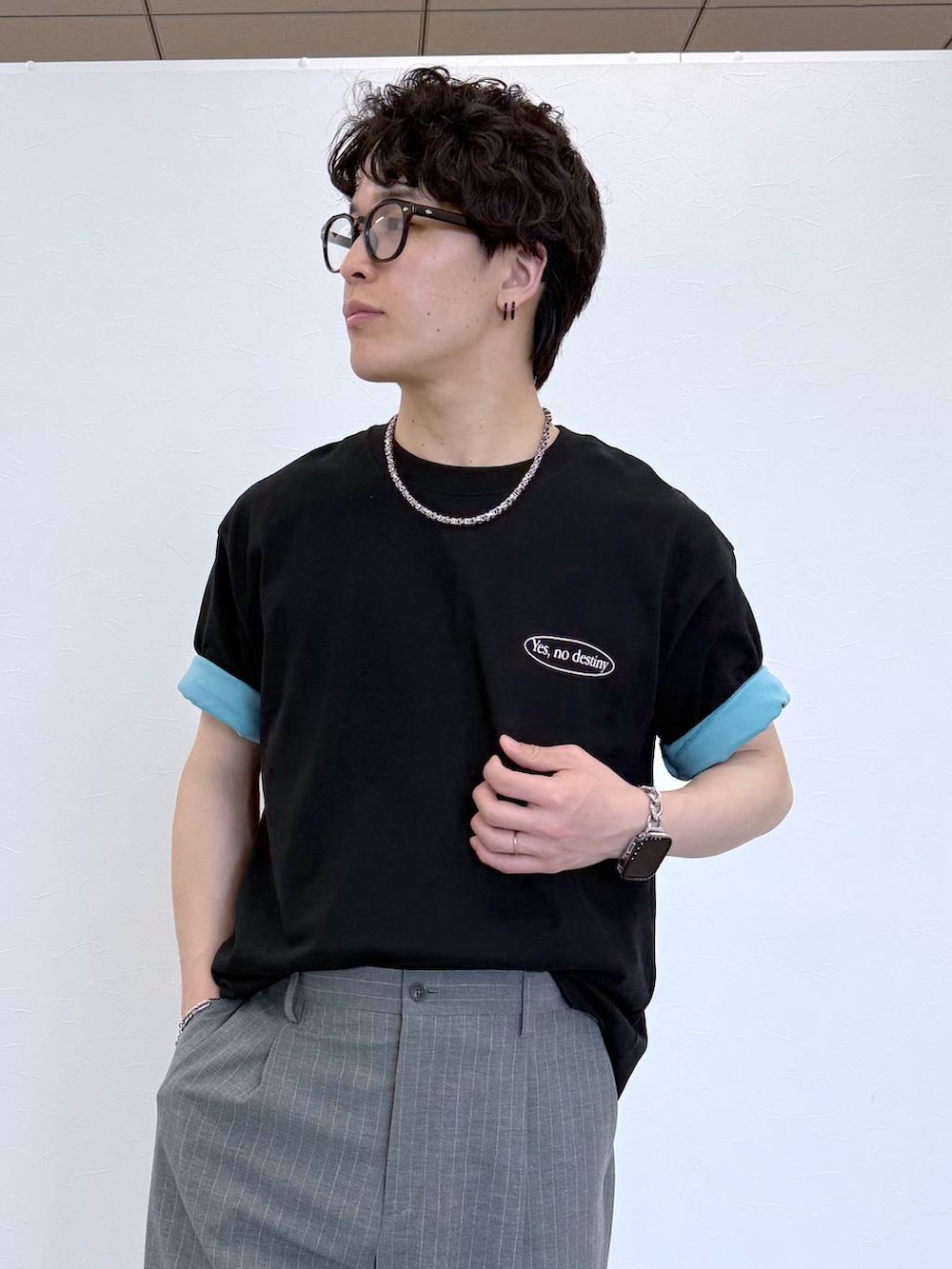 グレー系のスラックス、ブルー系のTシャツ/カットソー、ブラック系のサンダルを着用したメンズの夏コーディネートの6枚目の写真
