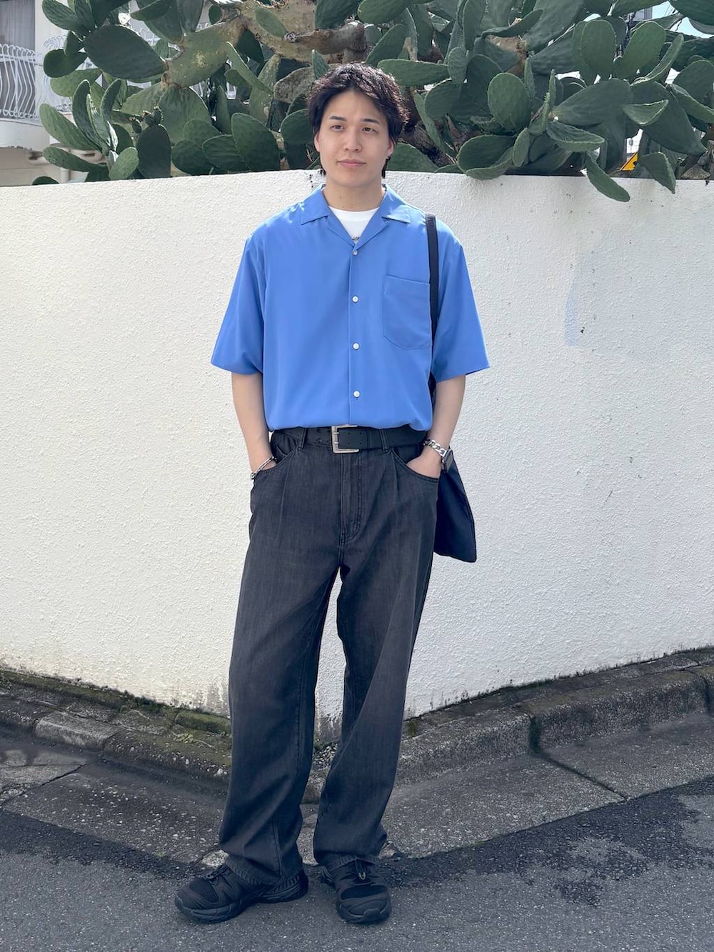ホワイト系のTシャツ/カットソー、ブラック系のスニーカー、グレー系のデニムパンツを着用したメンズの夏コーディネートの6枚目の写真