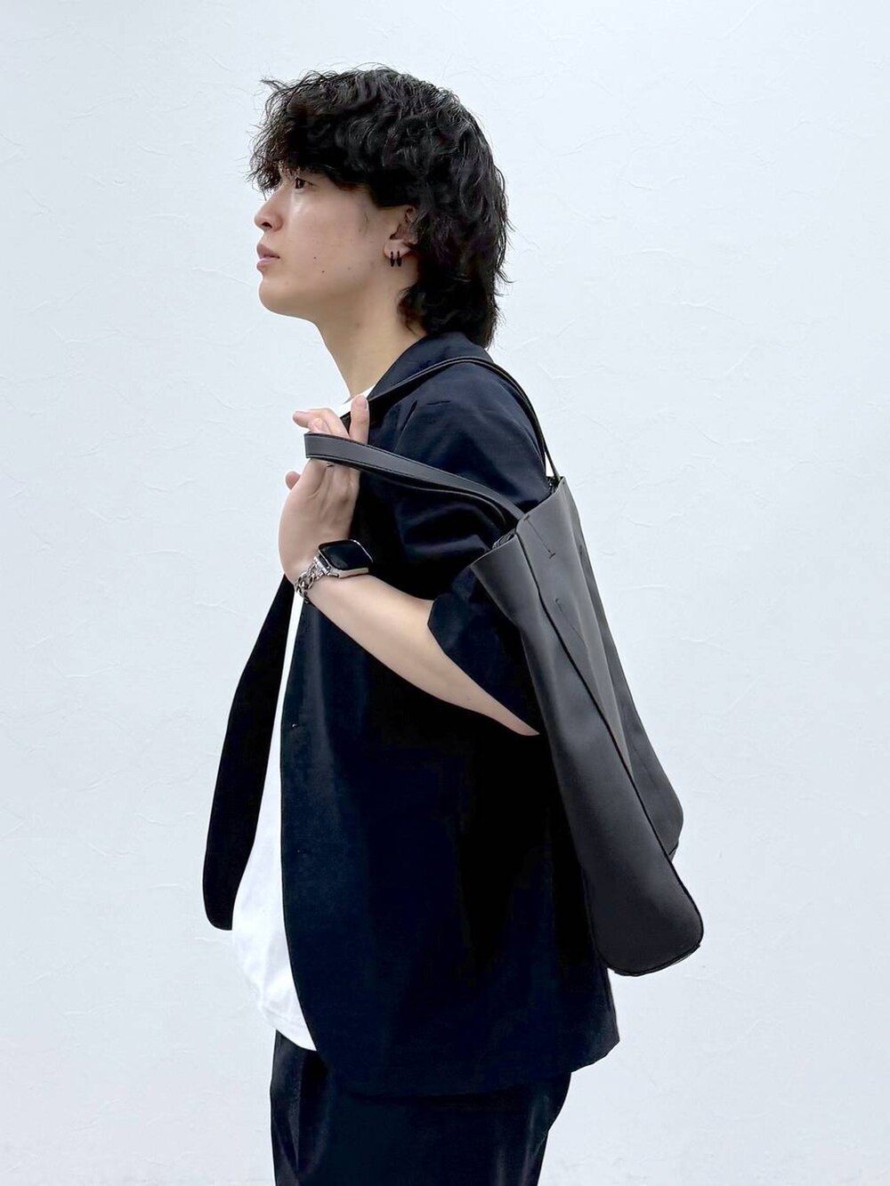 ブラック系のトートバッグ、ホワイト系のTシャツ/カットソー、ブルー系のノーカラージャケットを着用したメンズの春コーディネートの6枚目の写真