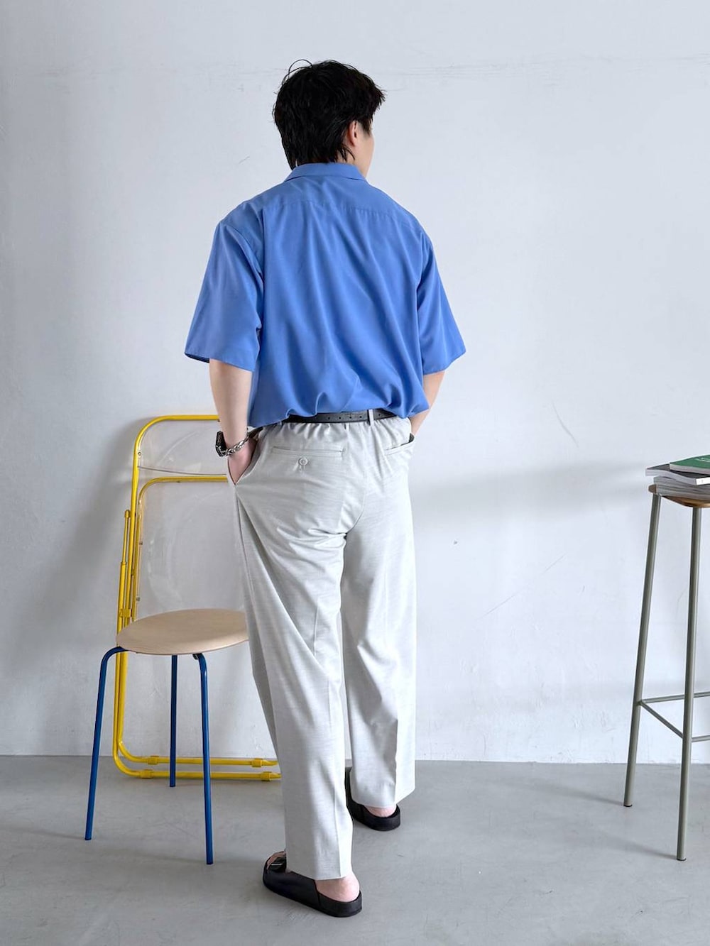 ホワイト系のスラックス、ホワイト系のTシャツ/カットソー、ブラック系のサンダルを着用したメンズの夏コーディネートの6枚目の写真