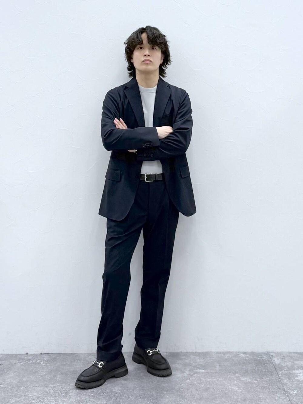 ブルー系のテーラードジャケット、ブルー系のスラックス、グレー系のニット/セーターを着用したメンズの春コーディネートの2枚目の写真