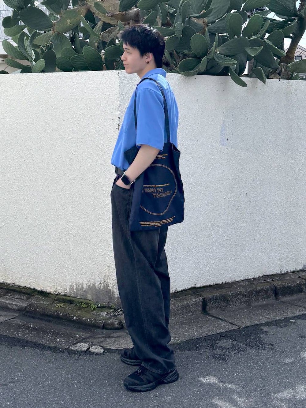 ホワイト系のTシャツ/カットソー、ブラック系のスニーカー、グレー系のデニムパンツを着用したメンズの夏コーディネートの8枚目の写真