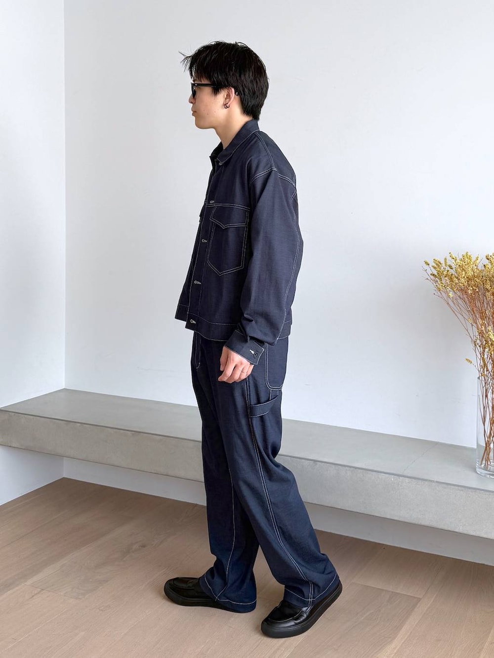 ブルー系のTシャツ/カットソー、グレー系のその他シューズ、ブルー系のデニムパンツを着用したメンズの秋コーディネートの3枚目の写真