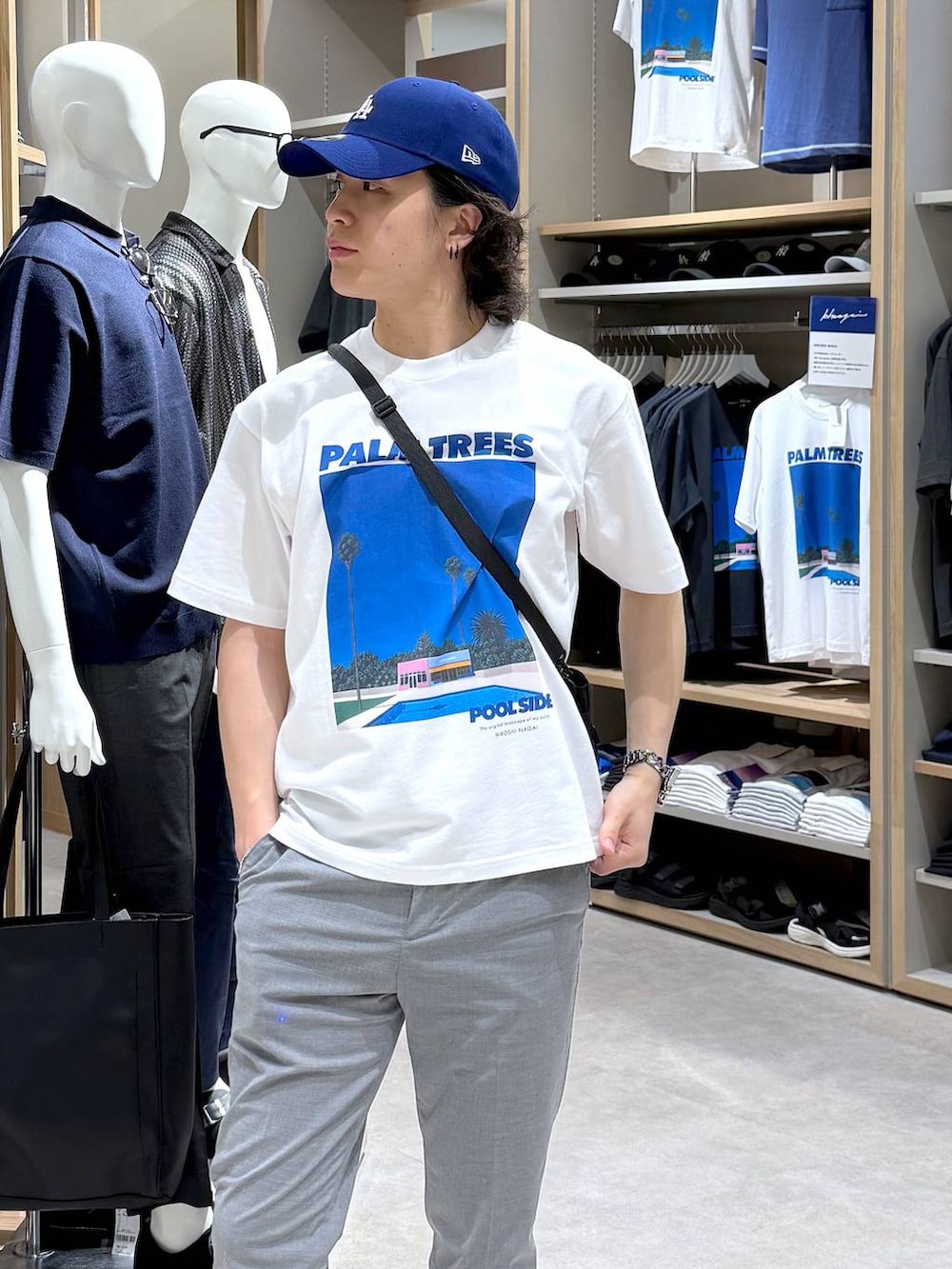 グレー系のスラックス、ホワイト系のサンダル、ブラック系のショルダーバッグを着用したメンズの夏コーディネートの3枚目の写真