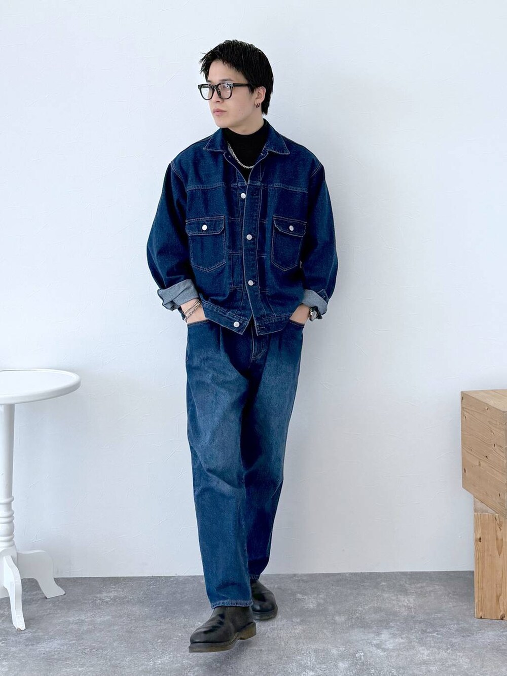 ブラック系のニット/セーター、ブルー系のデニムジャケット、ブルー系のデニムパンツを着用したメンズの秋コーディネートの3枚目の写真