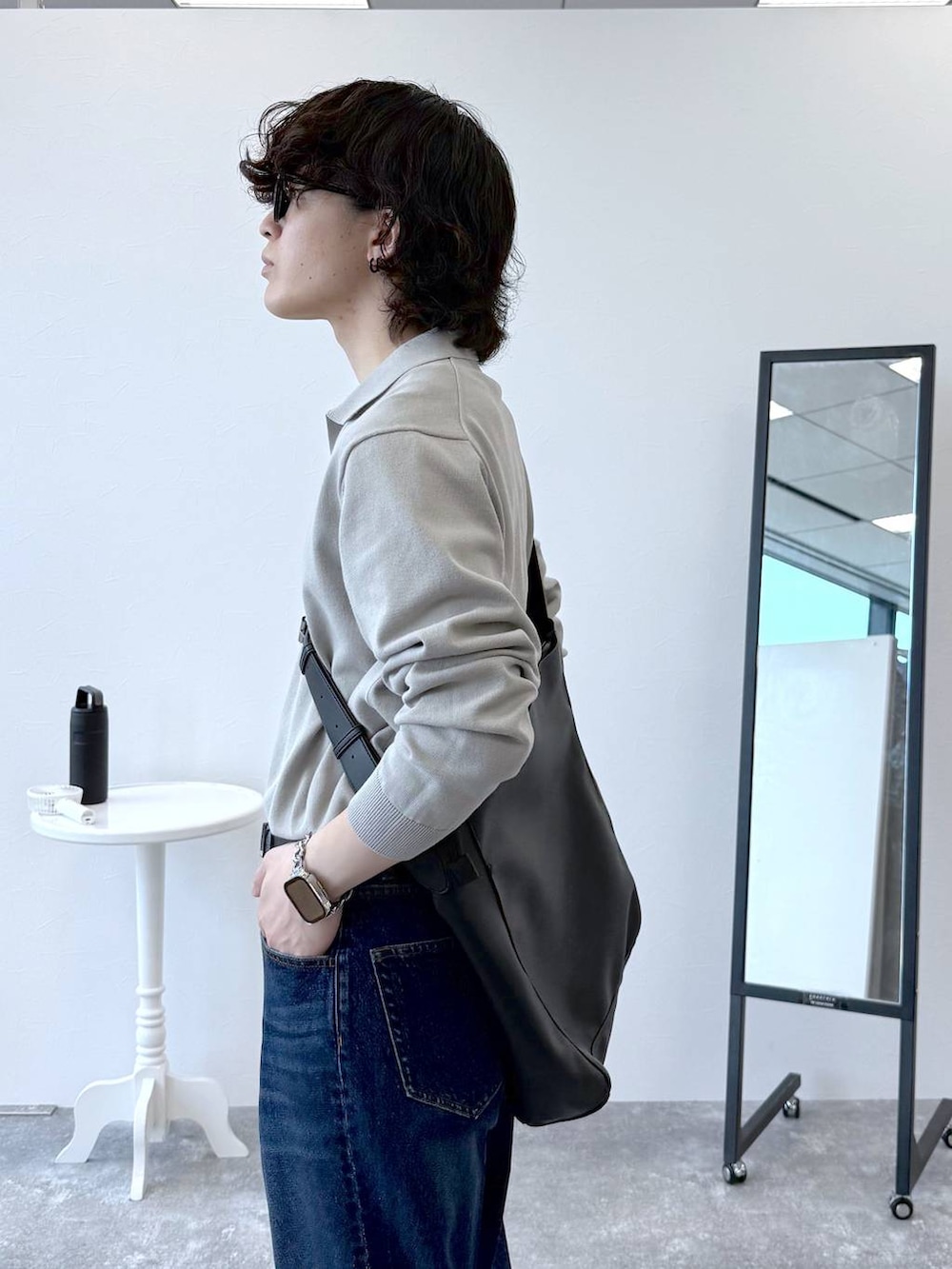 ブルー系のデニムパンツ、ベージュ系のニット/セーター、ブラック系のその他シューズを着用したメンズの秋コーディネートの6枚目の写真