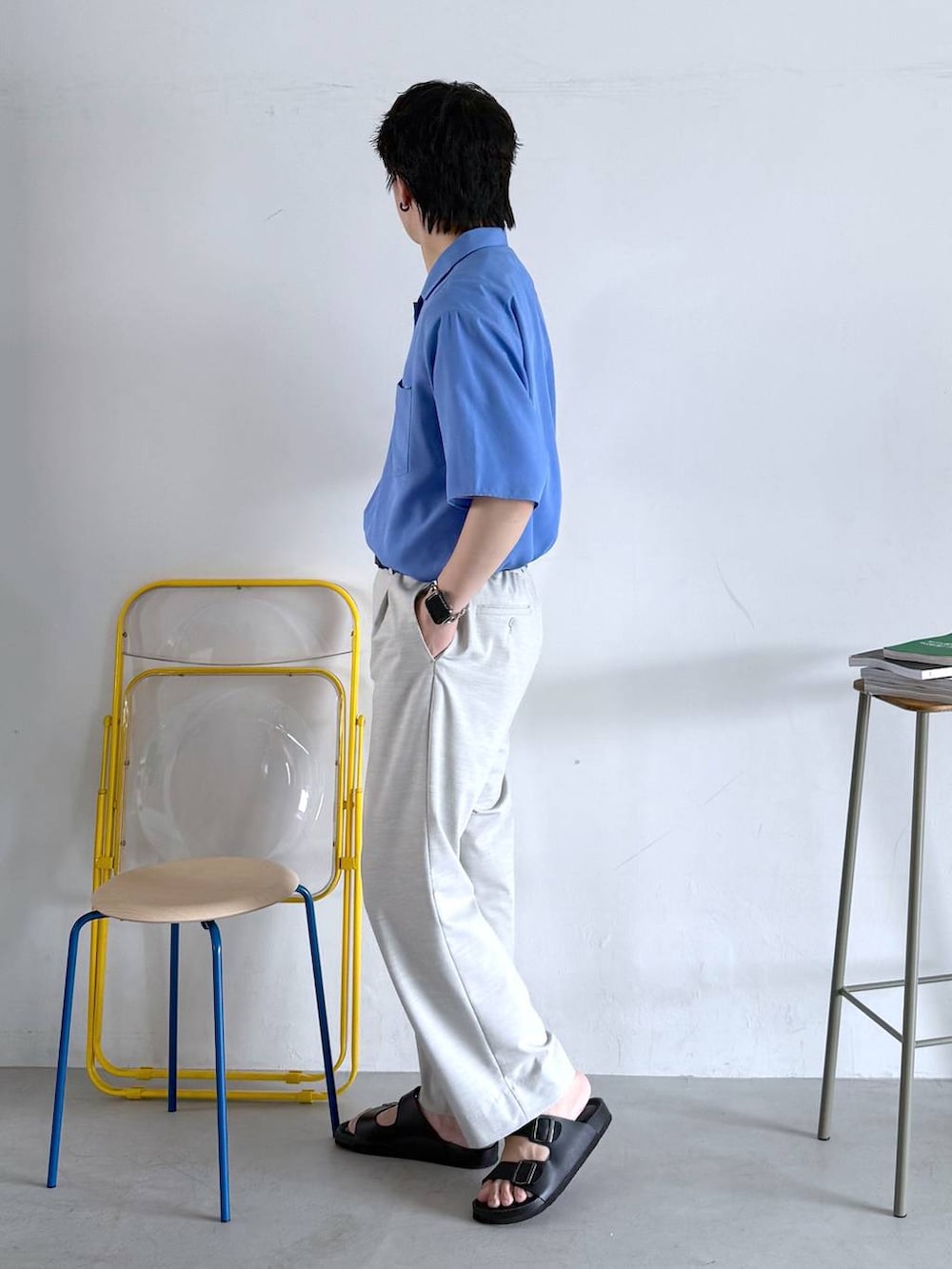 ホワイト系のスラックス、ホワイト系のTシャツ/カットソー、ブラック系のサンダルを着用したメンズの夏コーディネートの5枚目の写真