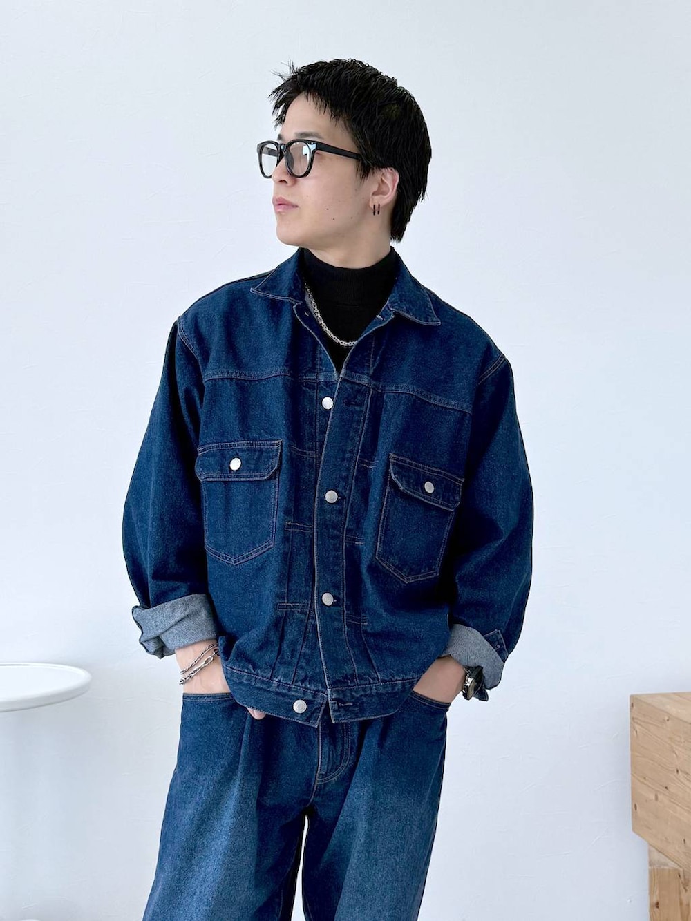 ブラック系のニット/セーター、ブルー系のデニムジャケット、ブルー系のデニムパンツを着用したメンズの秋コーディネートの7枚目の写真