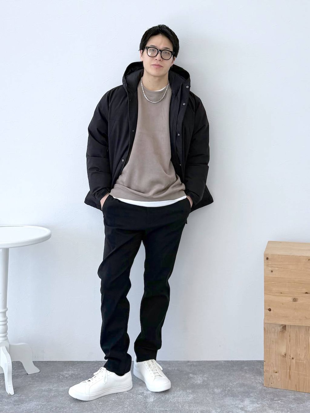 ブラック系のダウンジャケット/コート、ブラック系のその他パンツ、ホワイト系のTシャツ/カットソーを着用したメンズの冬コーディネートの2枚目の写真