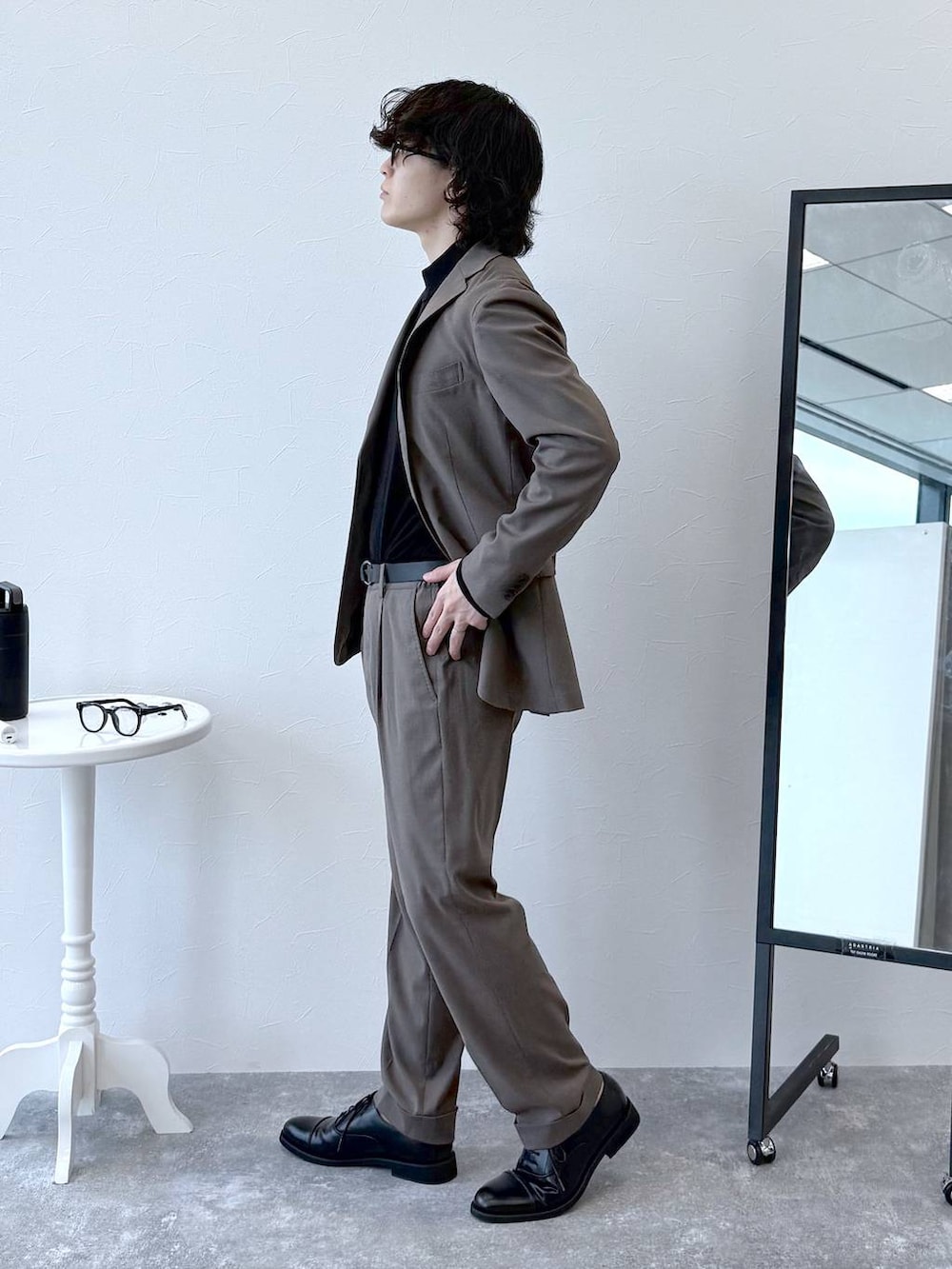 ブラウン系のテーラードジャケット、ブラウン系のスラックス、ブラック系のニット/セーターを着用したメンズの秋コーディネートの3枚目の写真