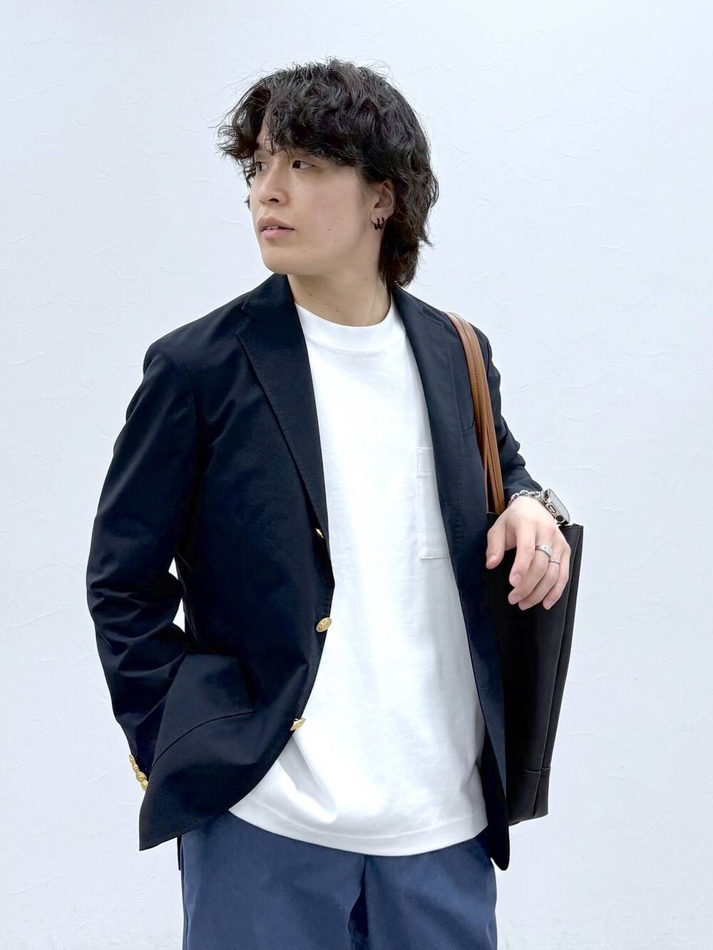 ブラック系のトートバッグ、ブルー系のその他パンツ、ホワイト系のTシャツ/カットソーを着用したメンズの春コーディネートの5枚目の写真