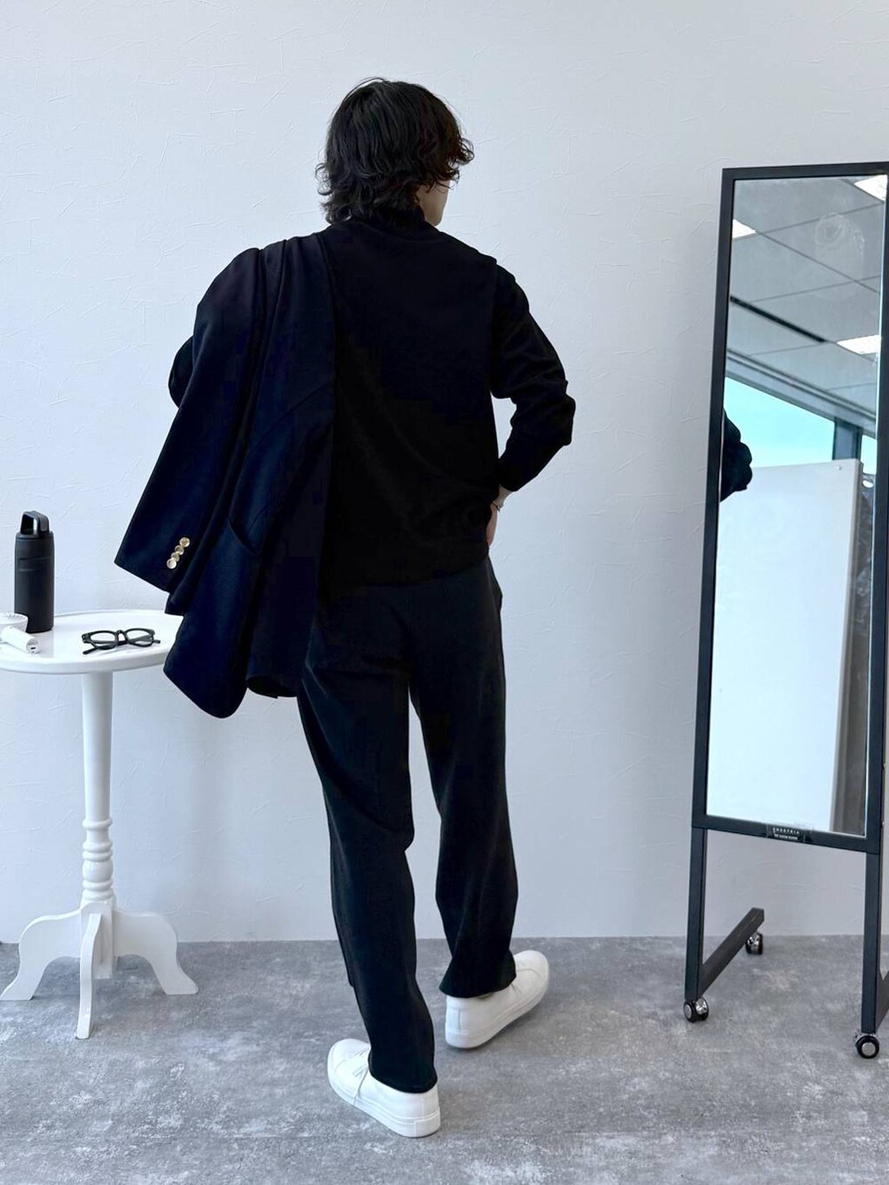 ブラック系のニット/セーター、ブルー系のテーラードジャケット、ブラック系のスラックスを着用したメンズの秋コーディネートの9枚目の写真