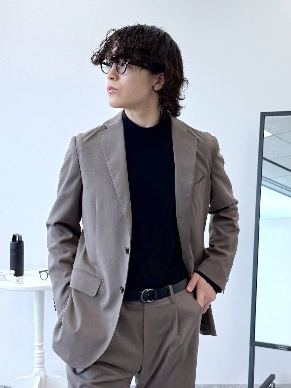 ブラウン系のテーラードジャケット、ブラウン系のスラックス、ブラック系のニット/セーターを着用したメンズの秋コーディネートの5枚目の写真