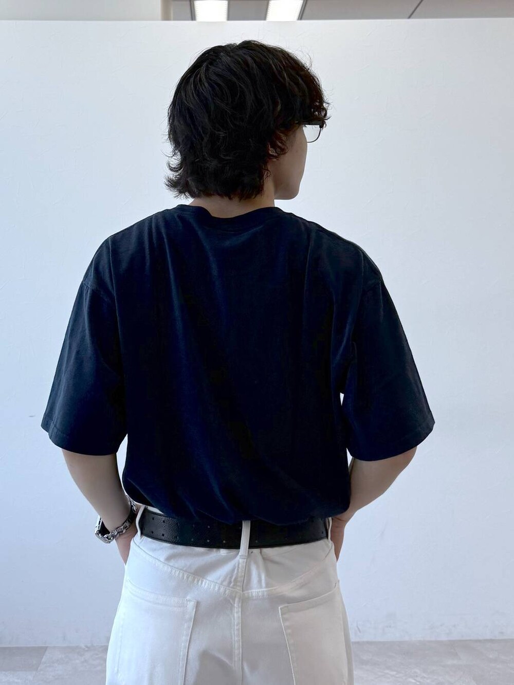 ブルー系のデニムパンツ、ブラック系のサンダル、ブルー系のTシャツ/カットソーを着用したメンズの夏コーディネートの7枚目の写真