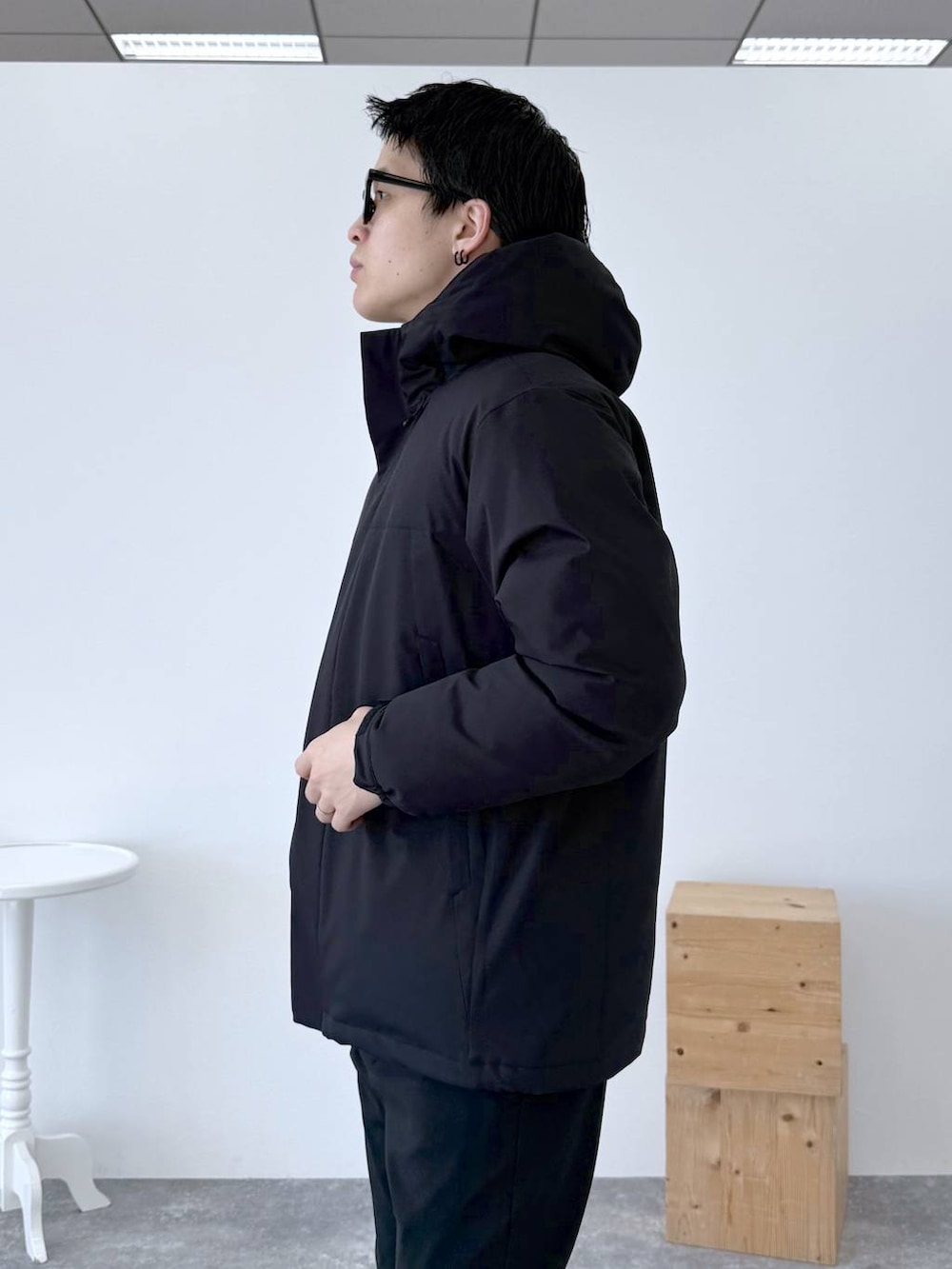ブラック系のダウンジャケット/コート、ブラック系のその他パンツ、ホワイト系のTシャツ/カットソーを着用したメンズの冬コーディネートの7枚目の写真