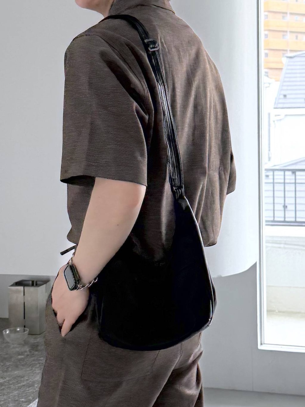 ブラック系のTシャツ/カットソー、ホワイト系のその他シューズ、ブラック系のショルダーバッグを着用したメンズの夏コーディネートの6枚目の写真