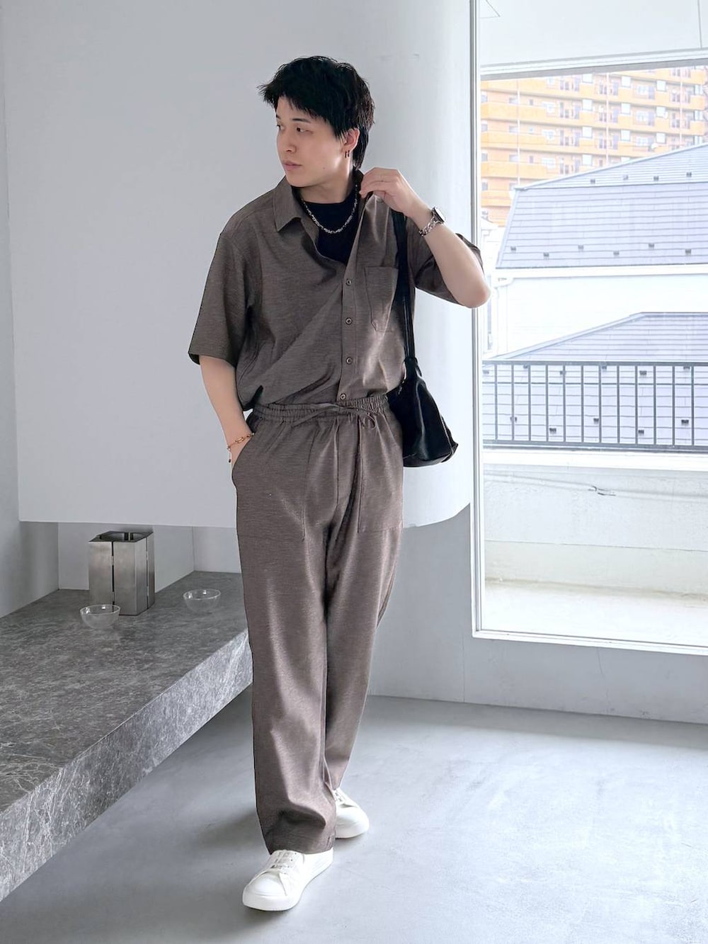 ブラック系のTシャツ/カットソー、ホワイト系のその他シューズ、ブラック系のショルダーバッグを着用したメンズの夏コーディネートの3枚目の写真