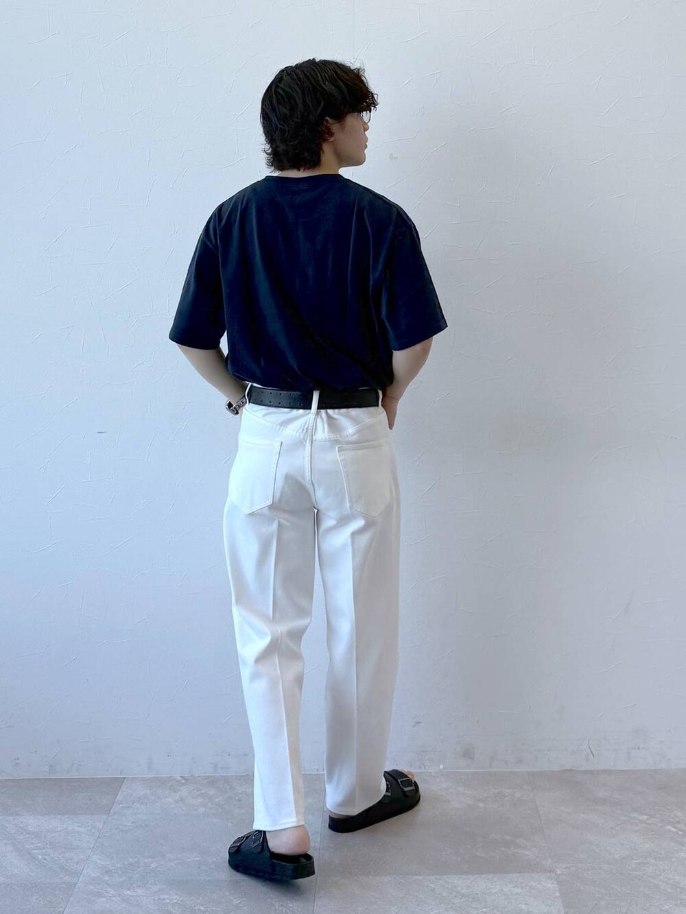 ブルー系のデニムパンツ、ブラック系のサンダル、ブルー系のTシャツ/カットソーを着用したメンズの夏コーディネートの4枚目の写真
