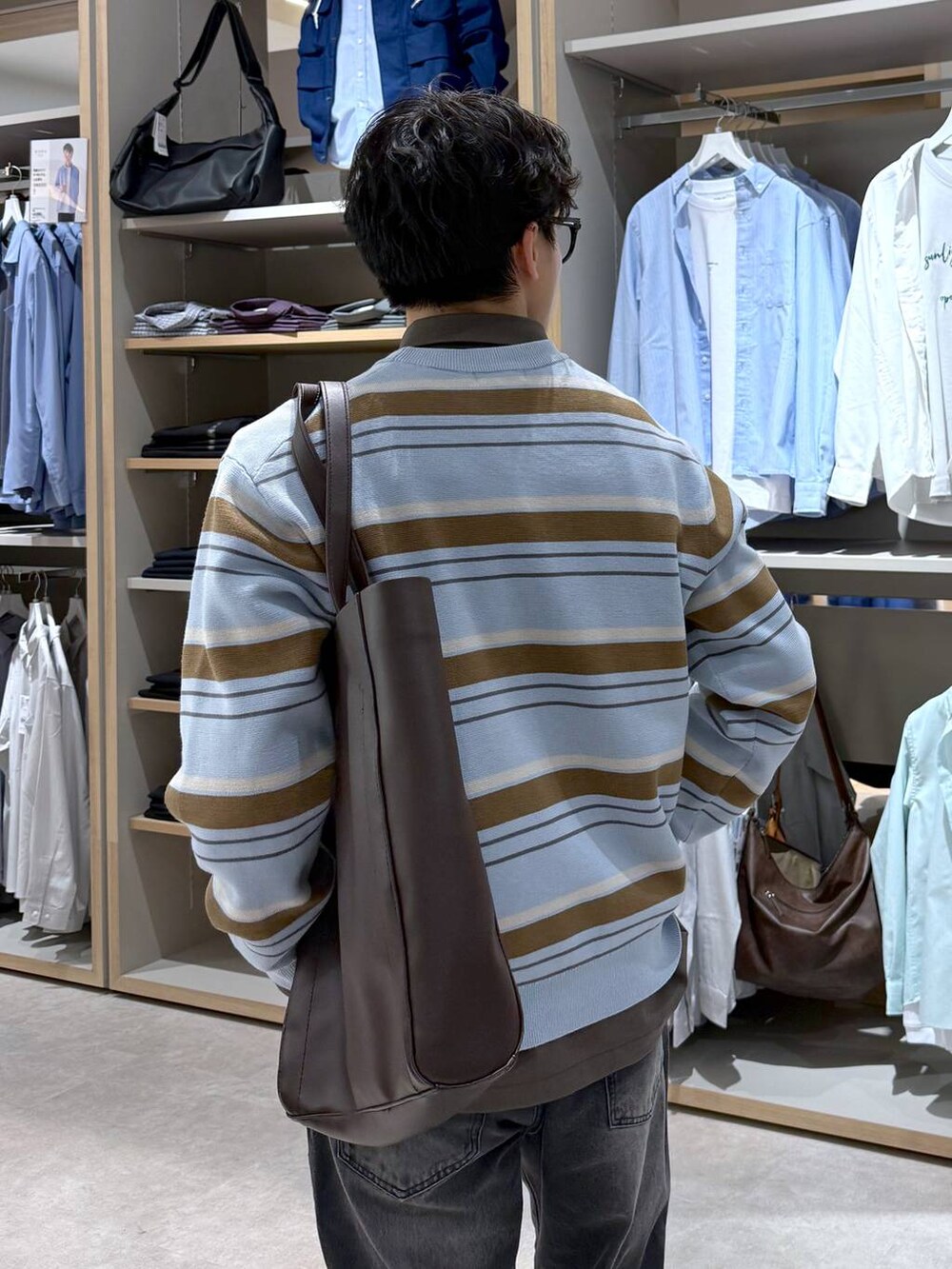 ブラック系のトートバッグ、ブルー系のニット/セーター、ブラウン系のシャツ/ブラウスを着用したメンズの春コーディネートの9枚目の写真