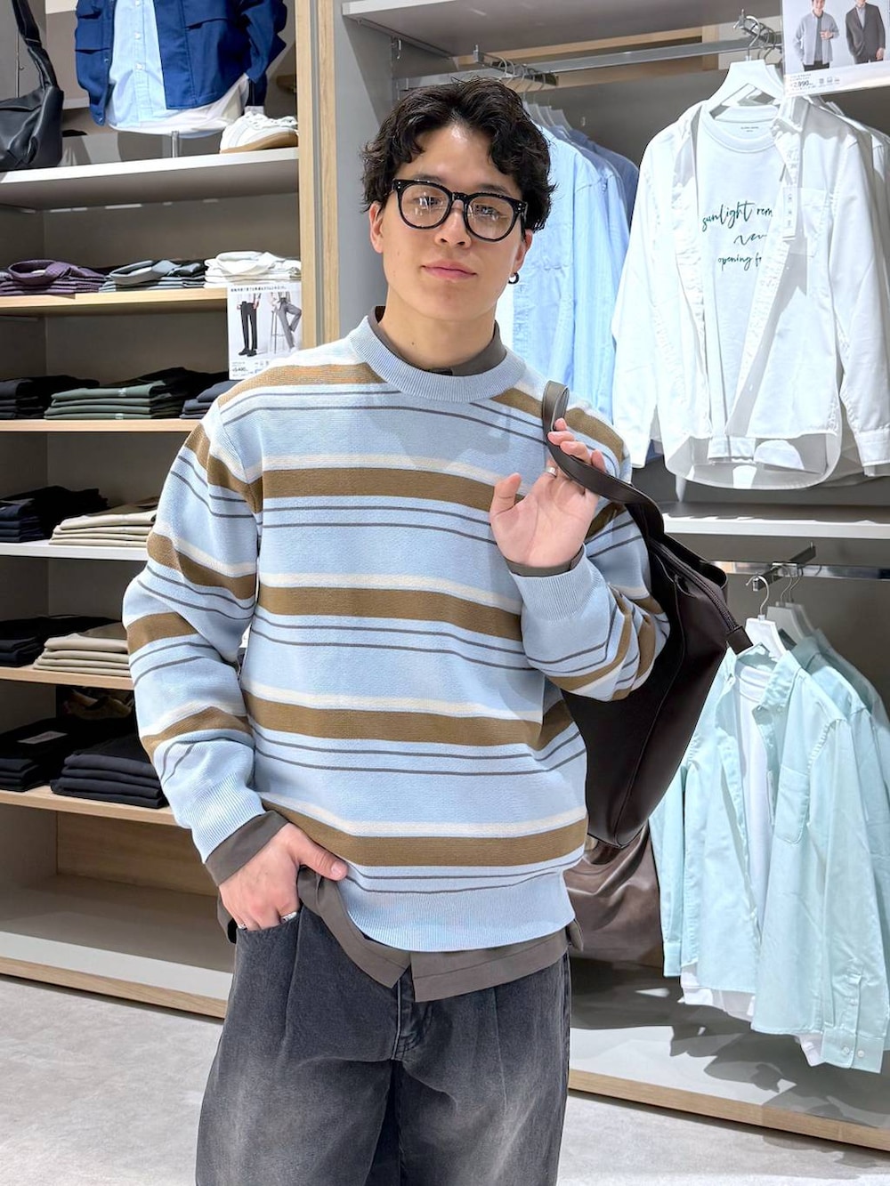 ブラック系のトートバッグ、ブルー系のニット/セーター、ブラウン系のシャツ/ブラウスを着用したメンズの春コーディネートの6枚目の写真