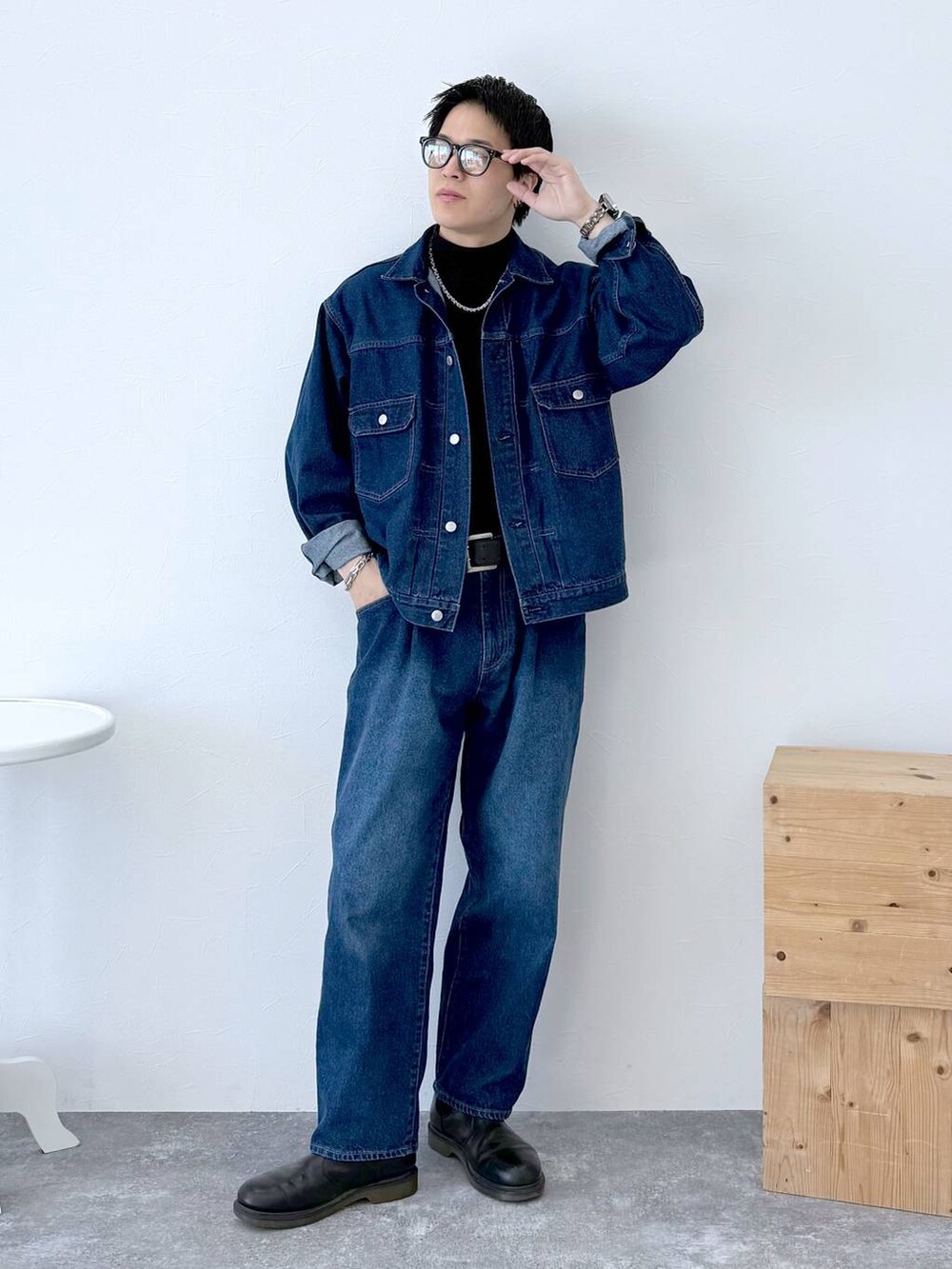 ブラック系のニット/セーター、ブルー系のデニムジャケット、ブルー系のデニムパンツを着用したメンズの秋コーディネートの2枚目の写真