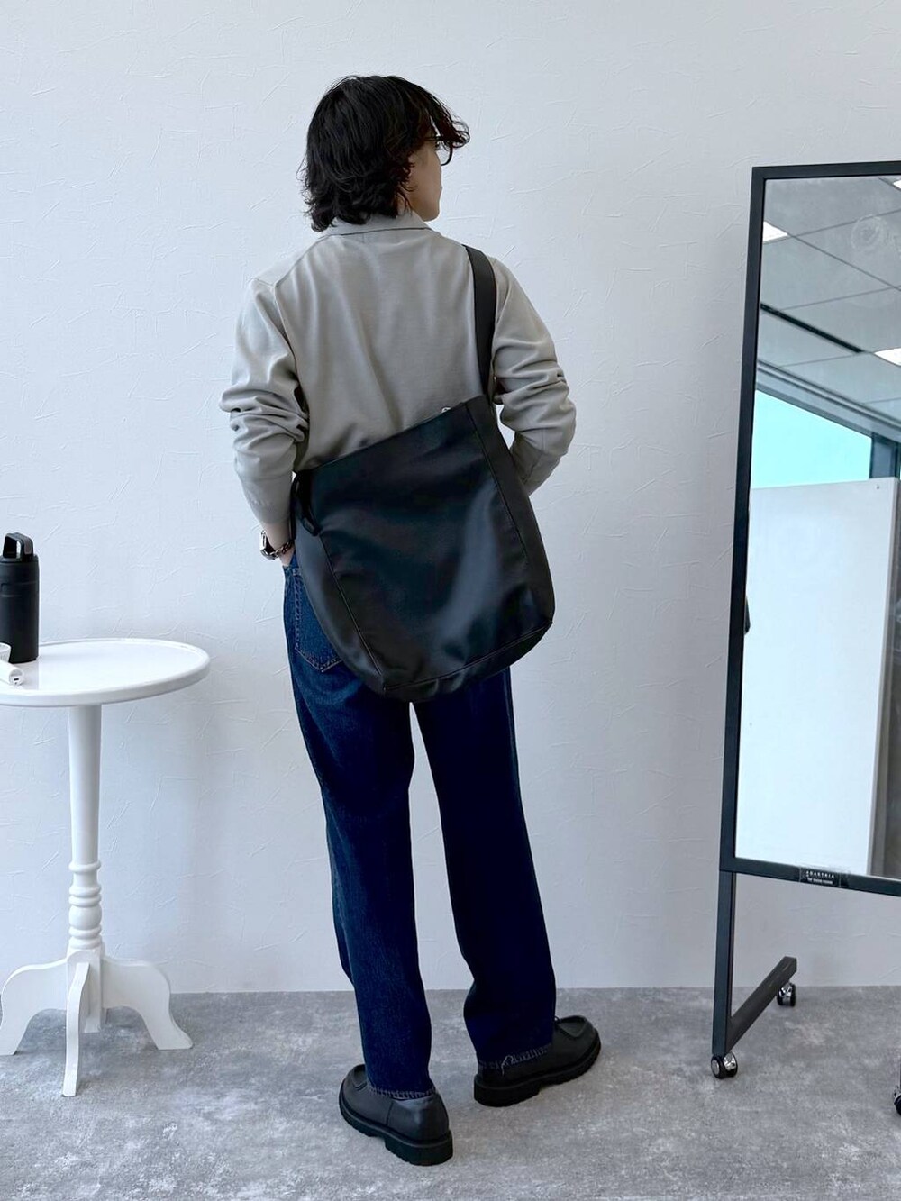 ブルー系のデニムパンツ、ベージュ系のニット/セーター、ブラック系のその他シューズを着用したメンズの秋コーディネートの4枚目の写真