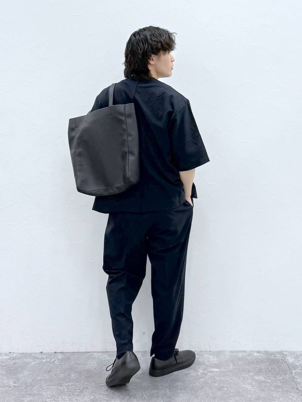 ブラック系のトートバッグ、ホワイト系のTシャツ/カットソー、ブルー系のノーカラージャケットを着用したメンズの春コーディネートの4枚目の写真