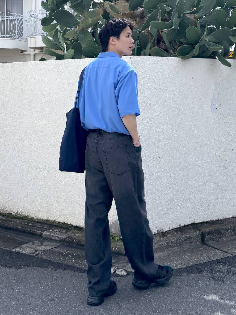 ホワイト系のTシャツ/カットソー、ブラック系のスニーカー、グレー系のデニムパンツを着用したメンズの夏コーディネートの5枚目の写真