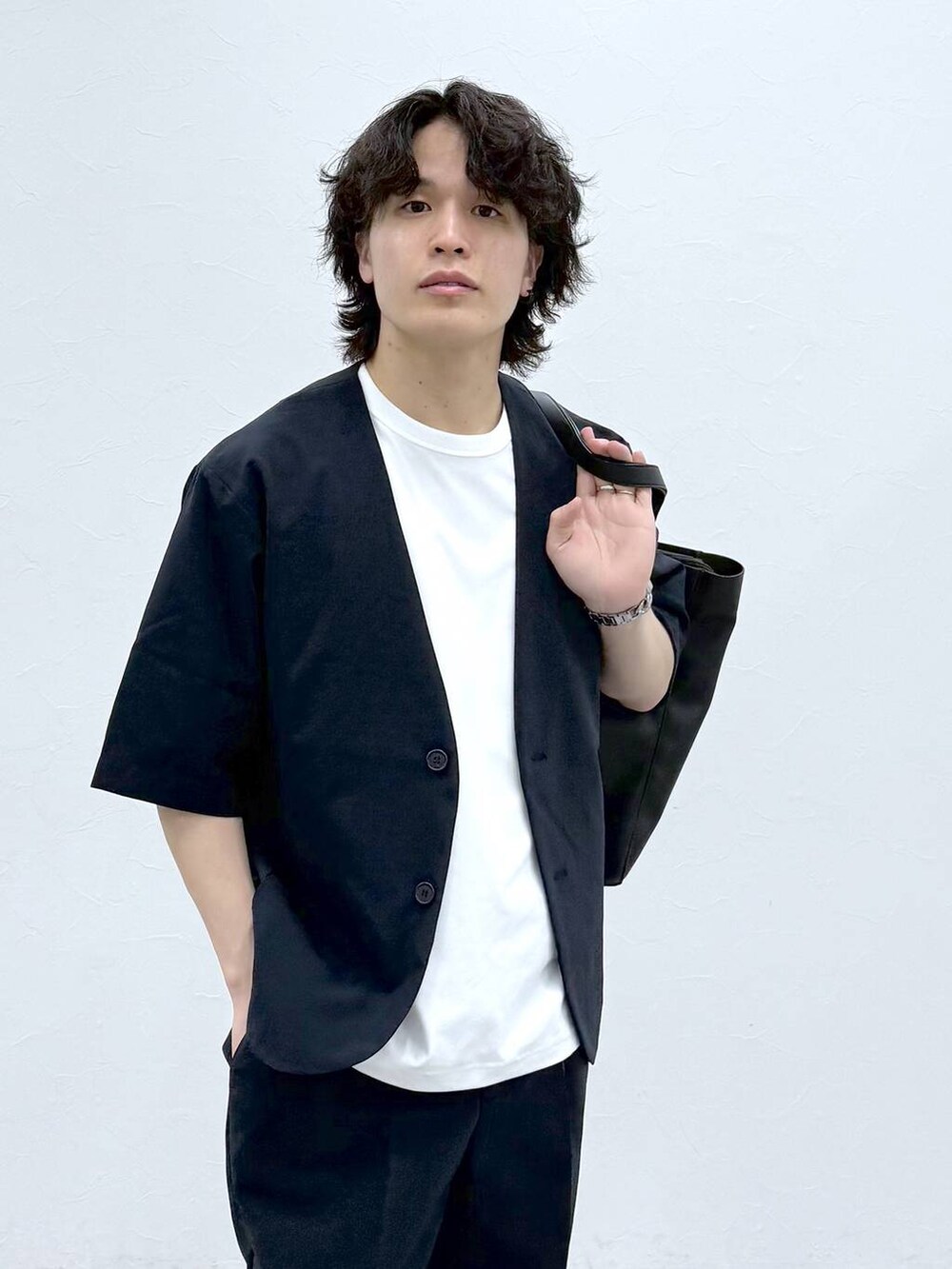 ブラック系のトートバッグ、ホワイト系のTシャツ/カットソー、ブルー系のノーカラージャケットを着用したメンズの春コーディネートの5枚目の写真