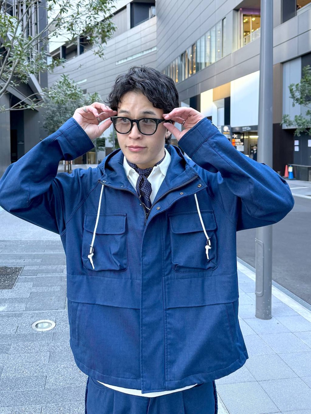 ブルー系のデニムパンツ、ブルー系のマウンテンパーカー、ブラック系のサングラスを着用したメンズの冬コーディネートの2枚目の写真