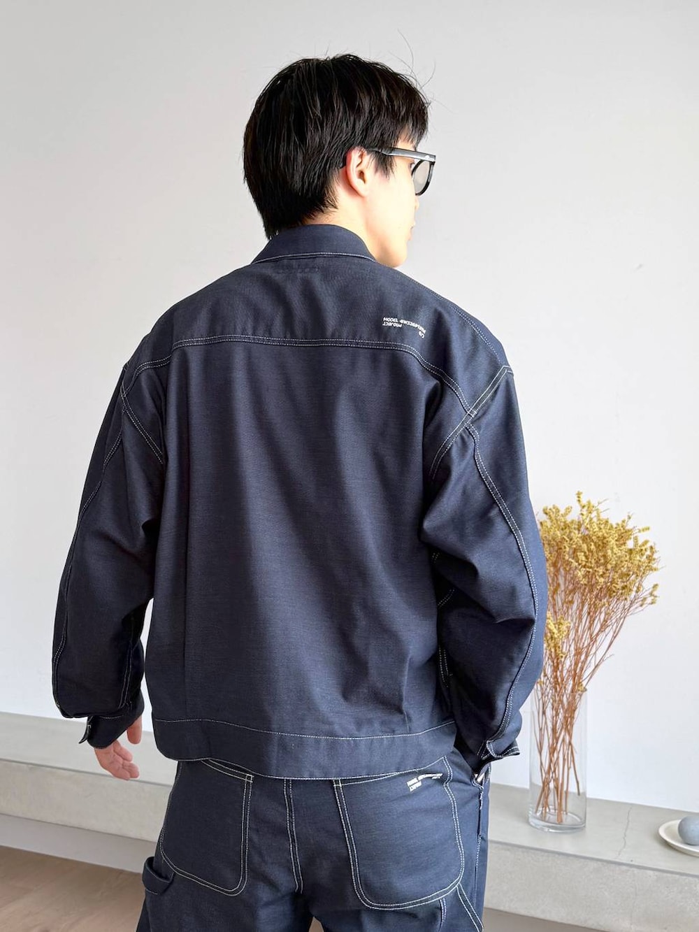 ブルー系のTシャツ/カットソー、グレー系のその他シューズ、ブルー系のデニムパンツを着用したメンズの秋コーディネートの7枚目の写真