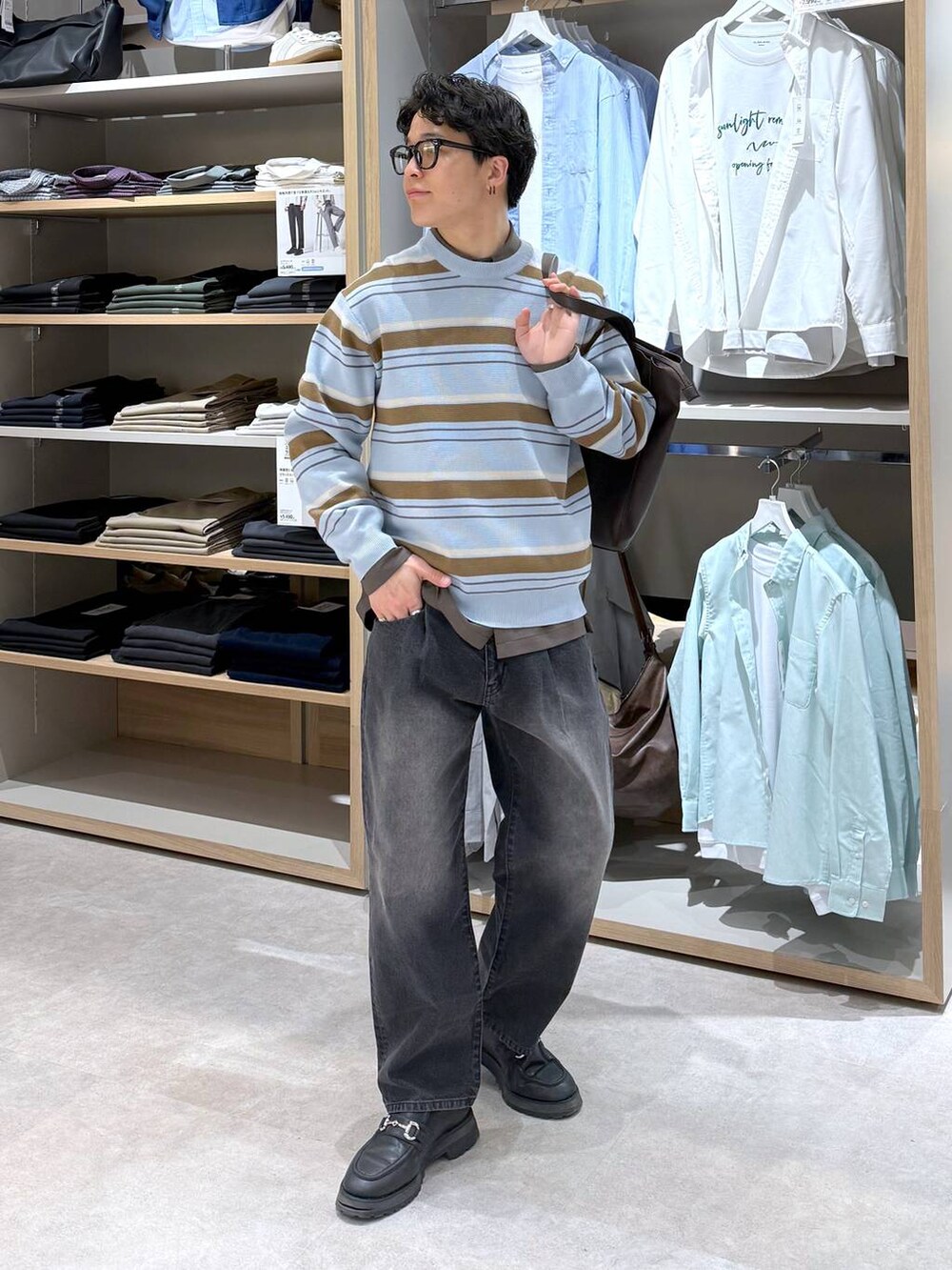 ブラック系のトートバッグ、ブルー系のニット/セーター、ブラウン系のシャツ/ブラウスを着用したメンズの春コーディネートの3枚目の写真