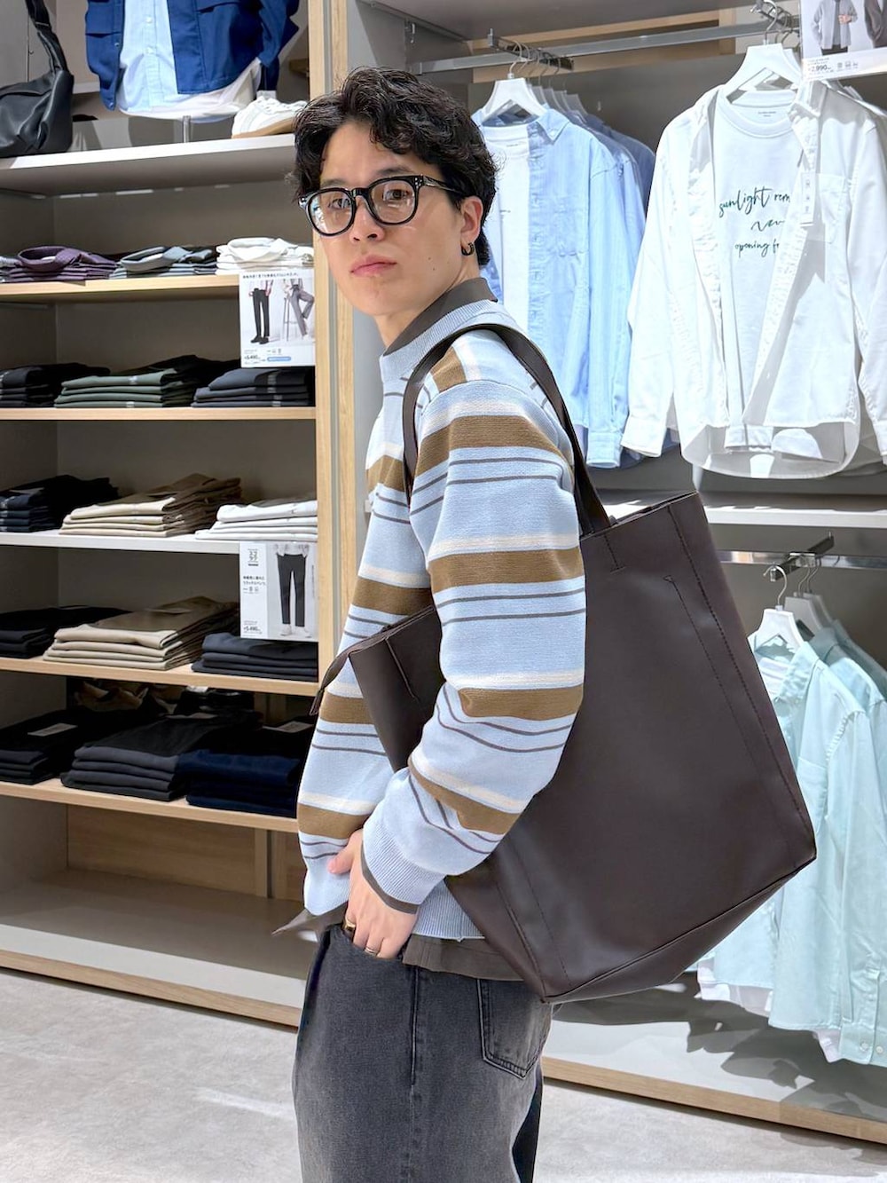 ブラック系のトートバッグ、ブルー系のニット/セーター、ブラウン系のシャツ/ブラウスを着用したメンズの春コーディネートの8枚目の写真