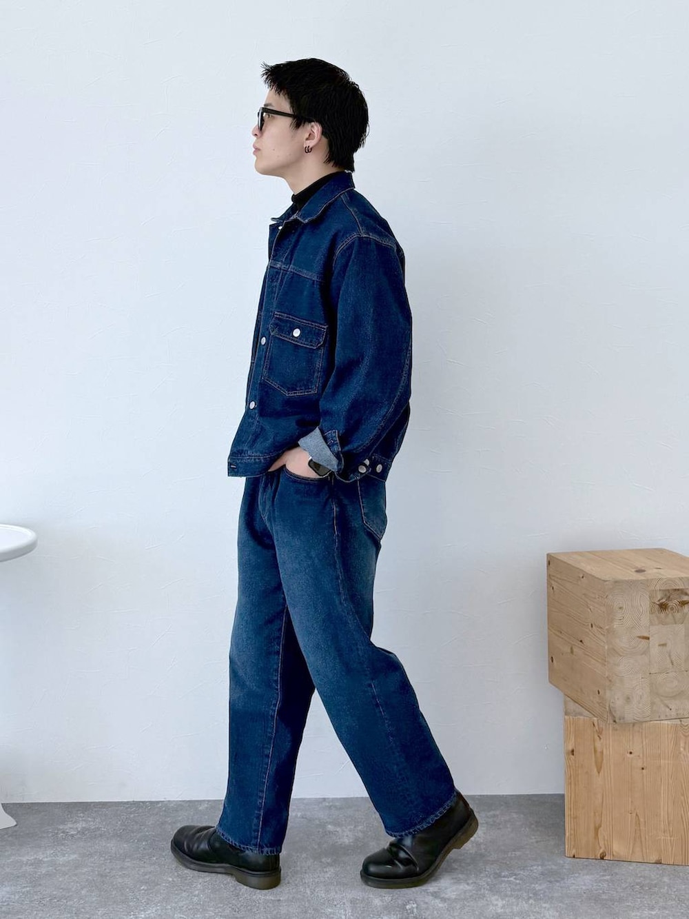 ブラック系のニット/セーター、ブルー系のデニムジャケット、ブルー系のデニムパンツを着用したメンズの秋コーディネートの4枚目の写真