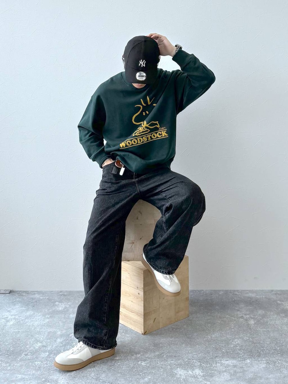 ベージュ系のスニーカー、ブラック系のデニムパンツ、ブラック系のキャップを着用したメンズの秋コーディネートの3枚目の写真