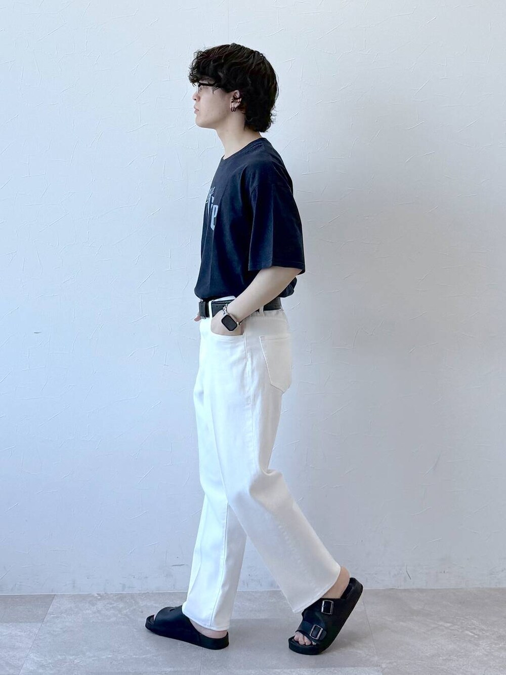 ブルー系のデニムパンツ、ブラック系のサンダル、ブルー系のTシャツ/カットソーを着用したメンズの夏コーディネートの3枚目の写真