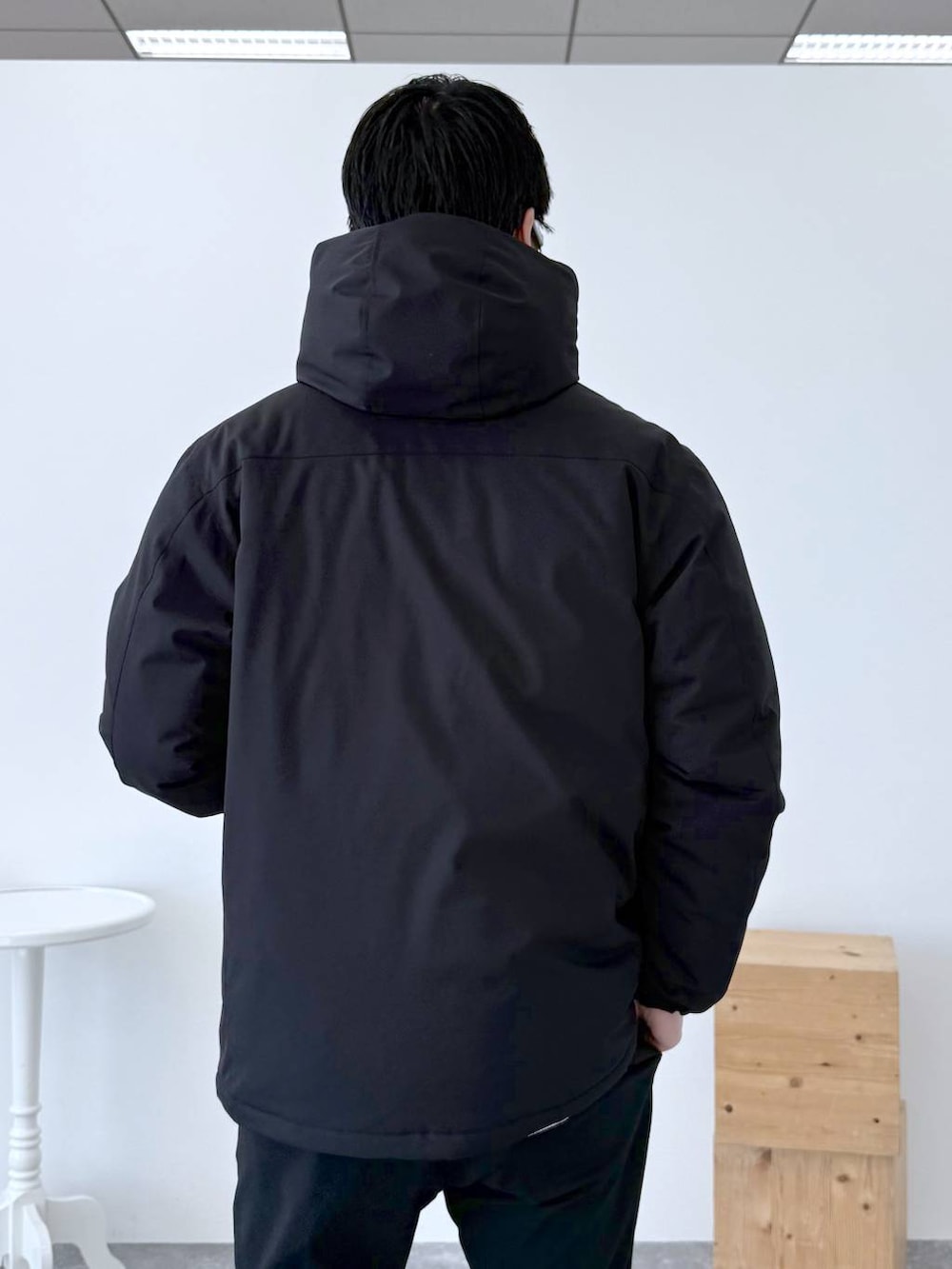 ブラック系のダウンジャケット/コート、ブラック系のその他パンツ、ホワイト系のTシャツ/カットソーを着用したメンズの冬コーディネートの8枚目の写真