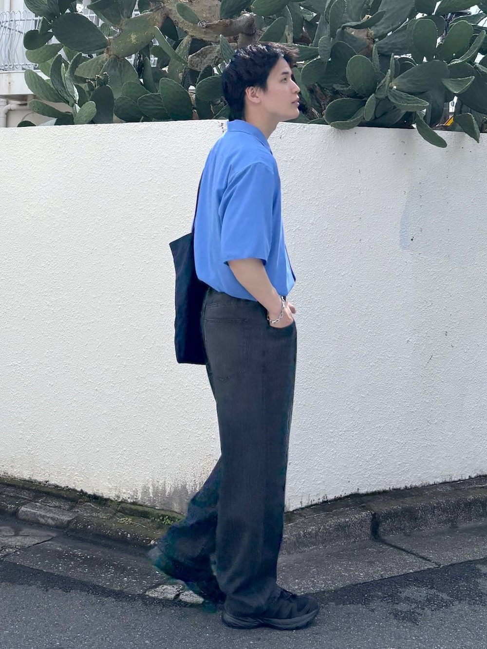 ホワイト系のTシャツ/カットソー、ブラック系のスニーカー、グレー系のデニムパンツを着用したメンズの夏コーディネートの4枚目の写真