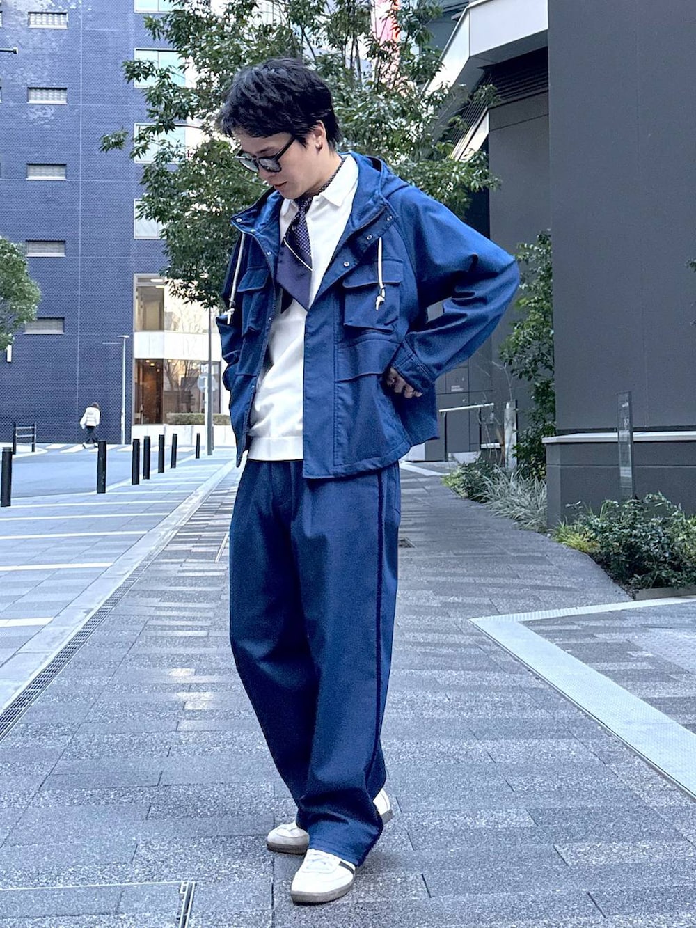 ブルー系のデニムパンツ、ブルー系のマウンテンパーカー、ブラック系のサングラスを着用したメンズの冬コーディネートの3枚目の写真