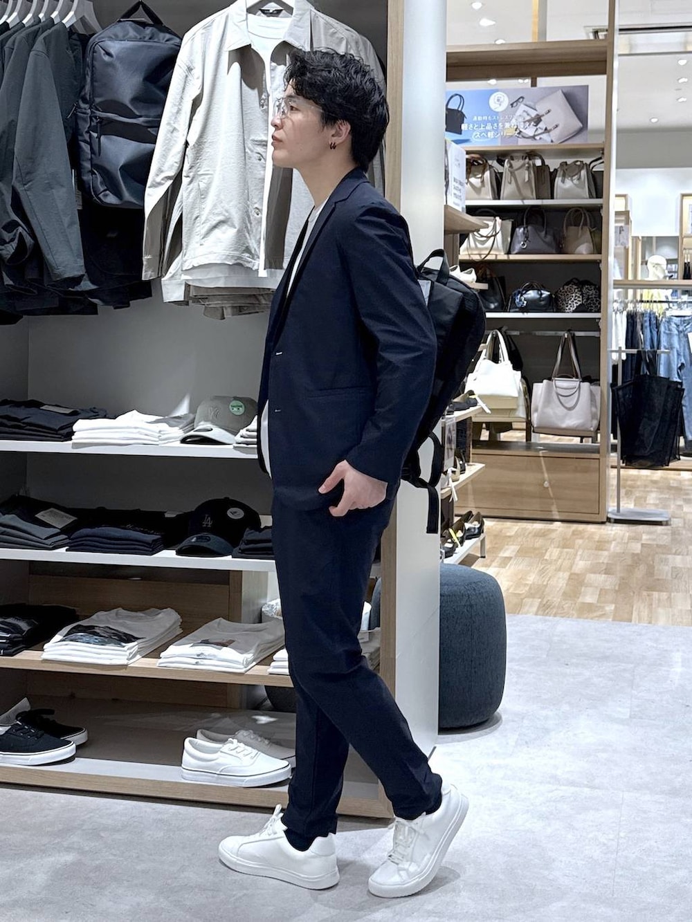 ブラック系のバックパック/リュック、ブルー系のその他パンツ、ブルー系のテーラードジャケットを着用したメンズの春コーディネートの4枚目の写真