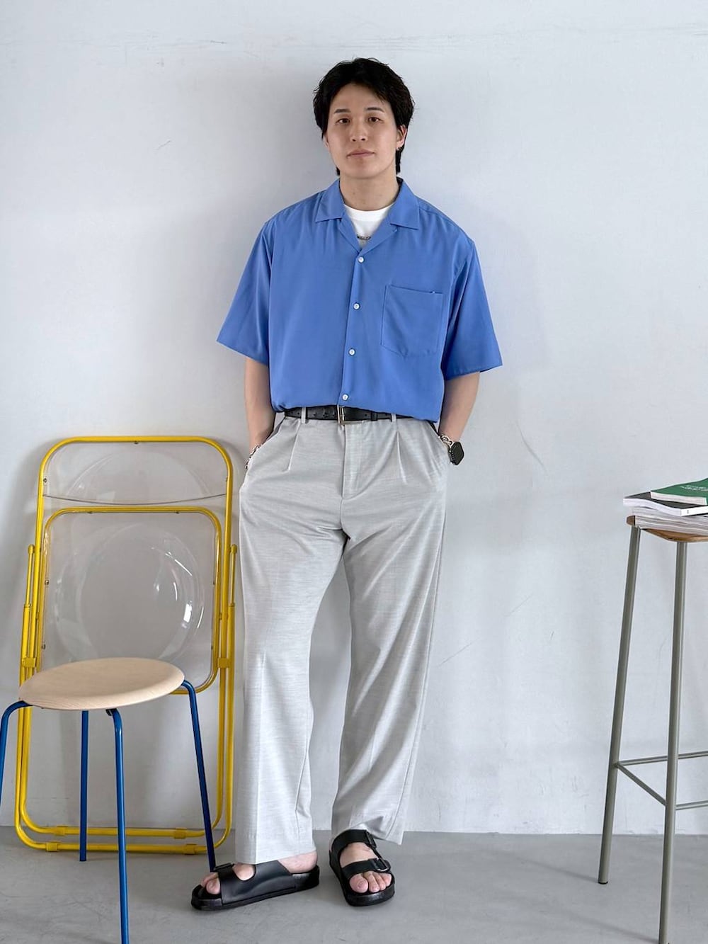ホワイト系のスラックス、ホワイト系のTシャツ/カットソー、ブラック系のサンダルを着用したメンズの夏コーディネートの2枚目の写真