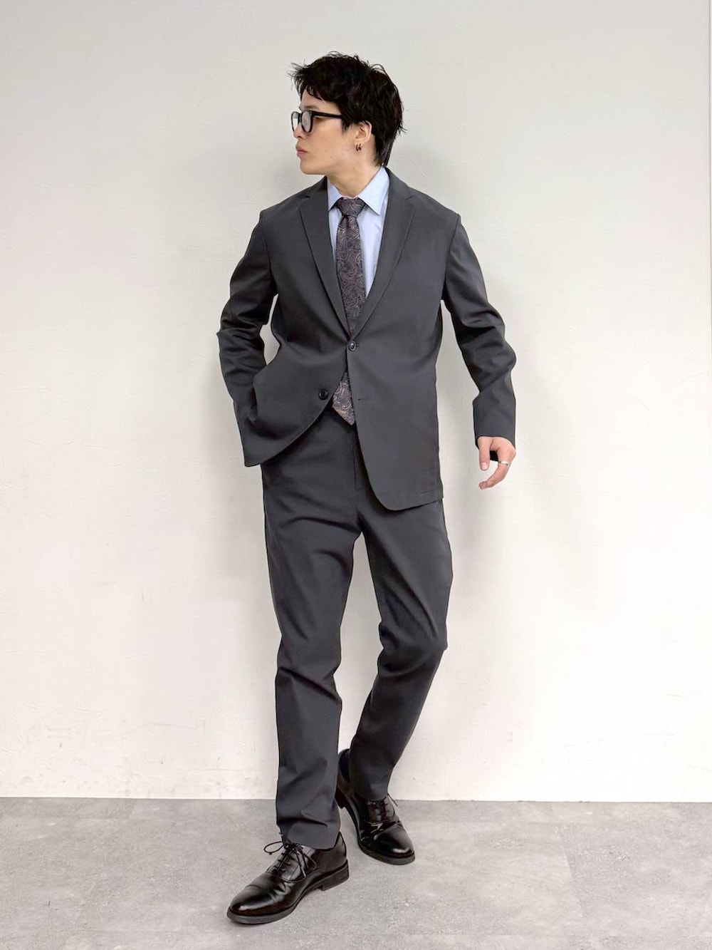 ブラック系のその他シューズ、ブルー系のシャツ/ブラウス、グレー系のテーラードジャケットを着用したメンズの冬コーディネートの3枚目の写真